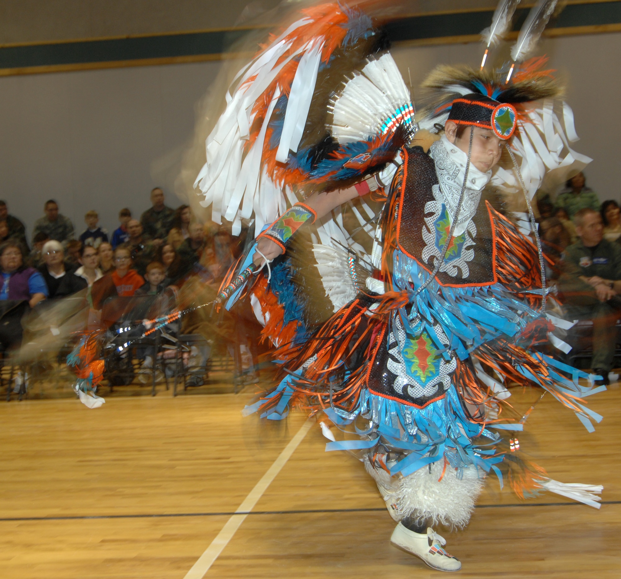 MOUNTAIN HOME AIR FORCE BASE, Idaho – A young member of the Shoshone-Paiute Tribe Dance Group performs a traditional Fancy Dance at the annual pow-wow celebration Jan. 25 at the Youth Center here. This contemporary, free style dance features soaring and swooping moves with men representing birds in flight and women representing graceful butterflies. Approximately 30 tribal members visited the base to perform this and other traditional songs and dances to share their culture with Gunfighters. (U.S. Air Force photo/ Airman 1st Class Stephany Miller)