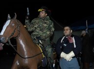 During his first visit to San Antonio's annual Cowboy Breakfast, Master Sgt. Torree White assists Dustin Mitchell rock through "guard duty" in the Bass Pro Shops parking lot on Jan. 25. Sergeant White is assigned to the 91st Network Warfare Squadron. Mr. Mitchell is a representative of the Buffalo Soldier's Living History and Heritage Association, one of the sponsorers of the Cowboy Breakfast. (USAF photo by April Rowden)                                