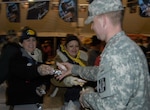 Army Pfc. Andrew Rowe takes a free tamale and breakfast taco during the Cowboy Breakfast Jan. 25. It is estimated that more than 45,000 people attended the event that serves as the official beginning to the San Antonio Stockshow and Rodeo. Private Rowe, assigned to C. Company 264 at Fort Sam Houston, is currently in nursing training.  (USAF photo by April Rowden)                              