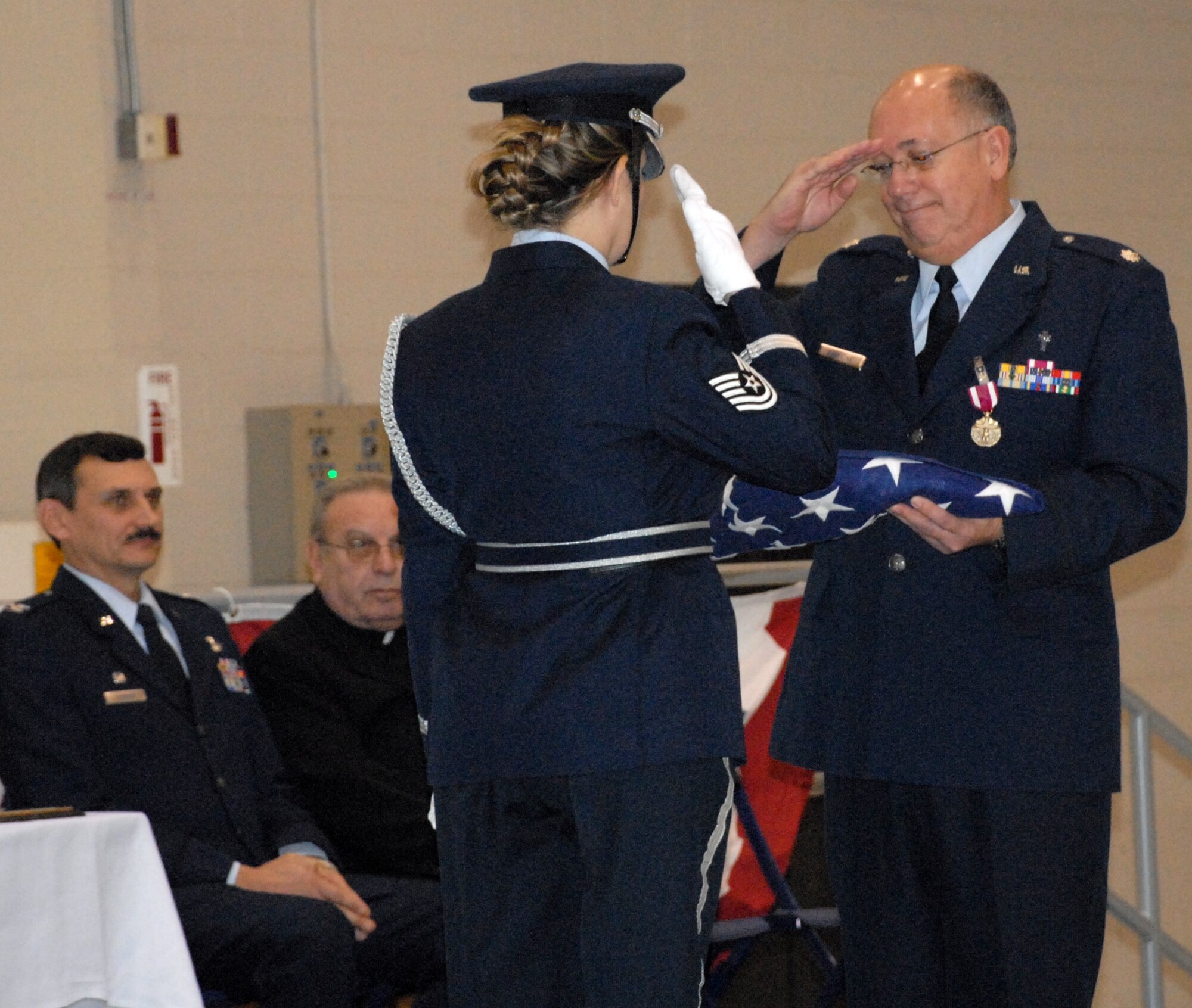 NIAGARA FALLS ARS, N.Y. - Lt. Col. (Father) John Gaglione, Catholic Chaplain for the 914th Airlift Wing, receives the U.S. Flag upon the occasion of his retirement while 914th Airlift Wing commander Col. Reinhard Schmidt and Bishop Edward Kmiec of the Buffalo Diocese look on.  Lt. Col. Gaglione retires from the Air Force Reserve after more than 24 years of dedicated and faithful service.  (U.S. Air Force photo/Tech. Sgt. Kevin Nichols)