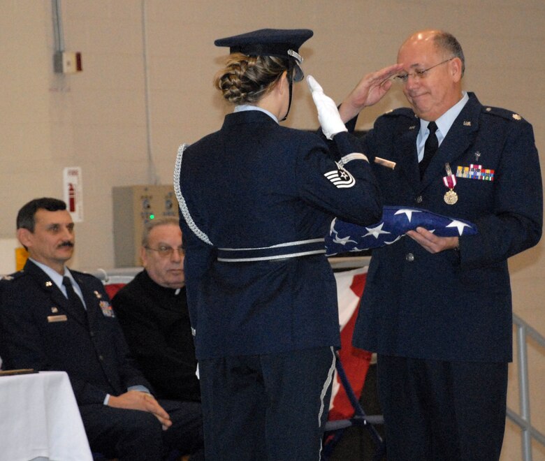 NIAGARA FALLS ARS, N.Y. - Lt. Col. (Father) John Gaglione, Catholic Chaplain for the 914th Airlift Wing, receives the U.S. Flag upon the occasion of his retirement while 914th Airlift Wing commander Col. Reinhard Schmidt and Bishop Edward Kmiec of the Buffalo Diocese look on.  Lt. Col. Gaglione retires from the Air Force Reserve after more than 24 years of dedicated and faithful service.  (U.S. Air Force photo/Tech. Sgt. Kevin Nichols)