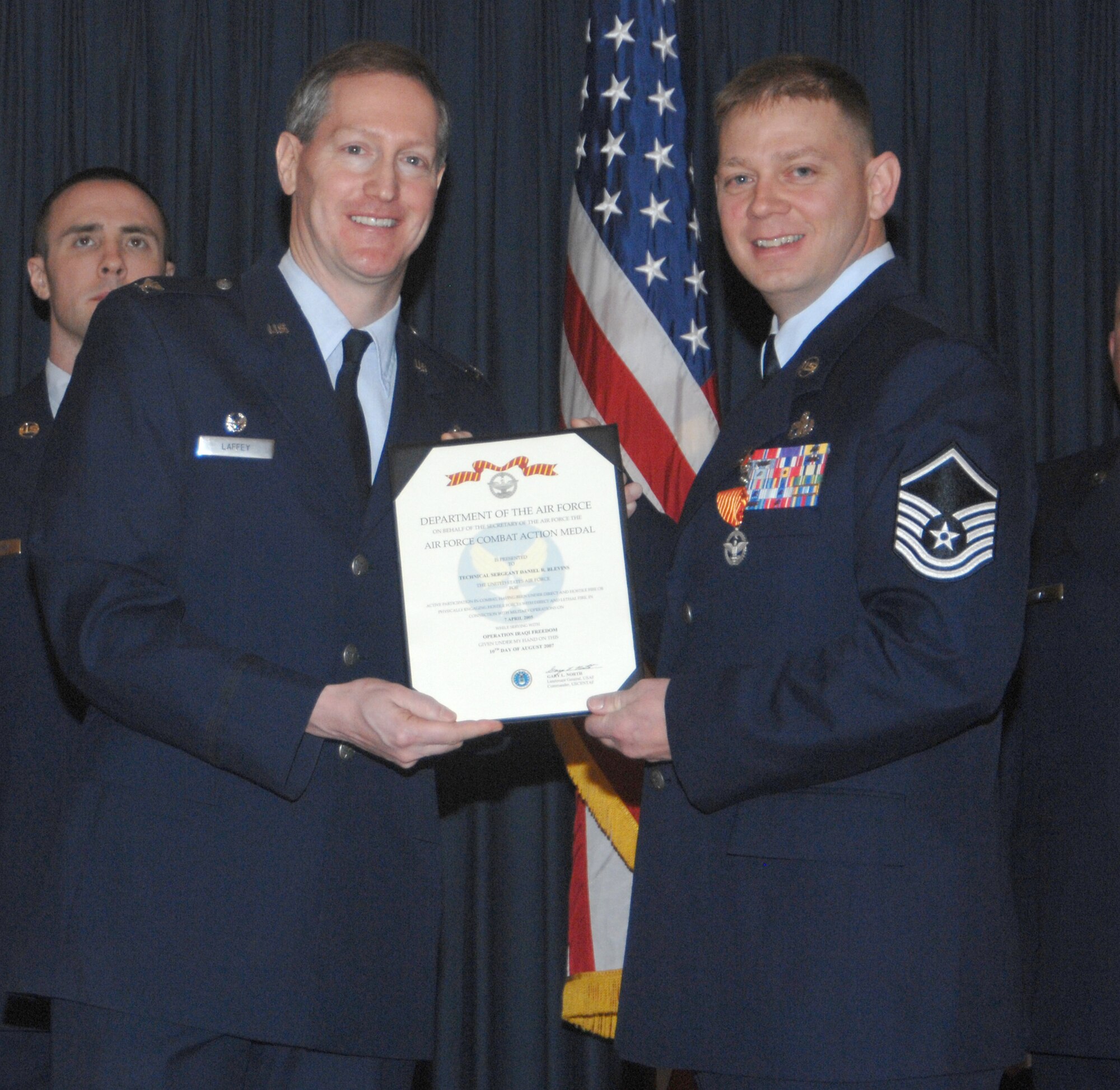 MOUNTAIN HOME AIR FORCE BASE, Idaho -- Left, Col. Thomas Laffey, 366th Mission Support Group commander, presents an Air Force Combat Action Medal to Tech. Sgt. Daniel Blevins, 366th Logistics Readiness Squadron, for actions in support of Operation Iraqi Freedom during an awards ceremony at the Gunfighter Club Jan. 25. On April 7, 2005, Sergeant Blevins sustained injuries while commanding a 40-vehicle convoy. After his vehicle was hit by an improvised explosive device and multiple passengers were injured, he continued command of the convoy until reaching its destination. Approved on March 15, 2007, the medal recognizes Airmen who actively participated in combat. (U.S. Air Force photo/Airman 1st Class Stephany Miller)
