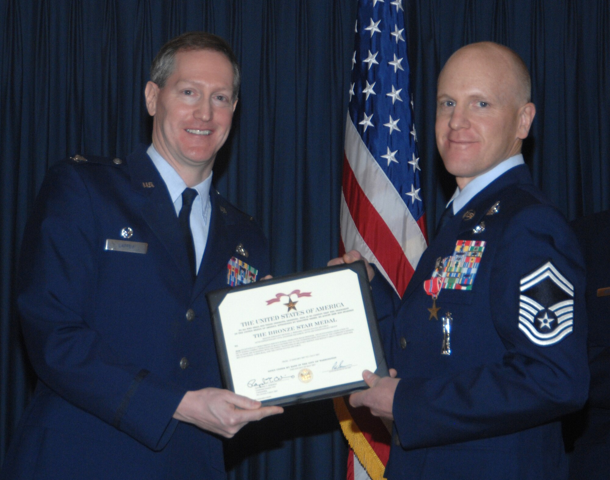 MOUNTAIN HOME AIR FORCE BASE, Idaho -- Left, Col. Thomas Laffey, 366th Mission Support Group commander, presents a Bronze Star Medal to Senior Master Sgt. David Ayers, 366th Civil Engineer Squadron, for actions in support of Operation Iraqi Freedom from Jan. 12 to July 1, 2007, during an awards ceremony at the Gunfighter Club Jan. 25. Sergeant Ayers distinguished himself by exceptionally meritorious conduct in performance of outstanding service to the U.S. as part of the explosive ordnance disposal flight, 447th Expeditionary Civil Engineer Squadron, Sather AB, Iraq, from Jan. 13 to July 1, 2007. First authorized on Feb. 4, 1944, to recognize ground troops, the bronze star is the fourth highest award for bravery, heroism or meritorious service. (U.S. Air Force photo/Airman 1st Class Stephany Miller)