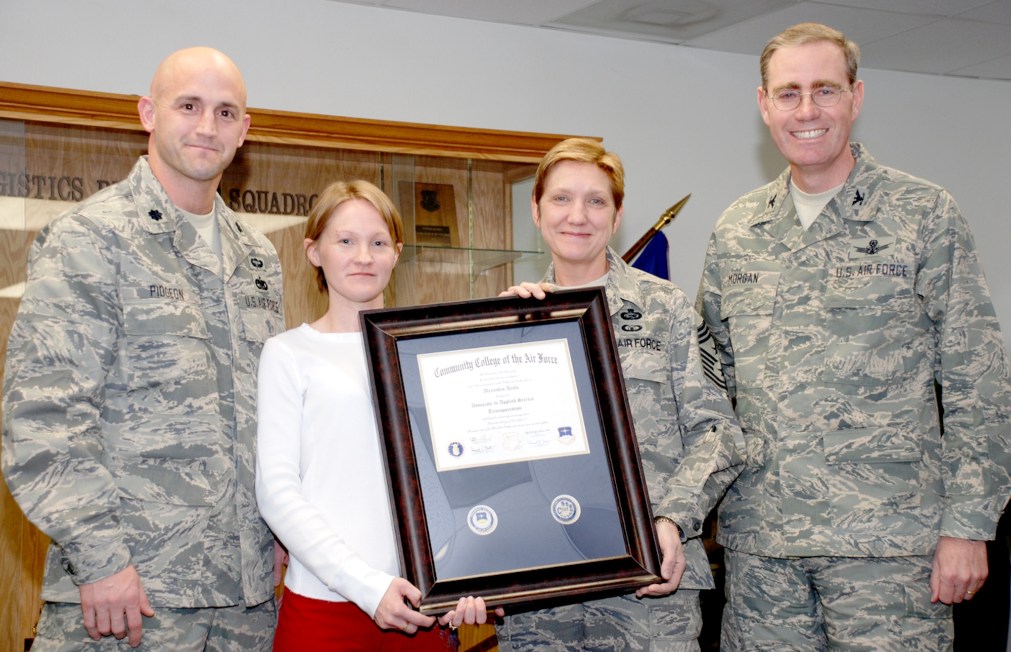 Lt. Col. Paul Pidgeon, 90th Logistics Readiness Squadron commander; Command Chief Master Sgt. Tammy S. Elliott, 90th Space Wing; and Col. Mike Morgan, 90th SW commander, present Meagan Ayala with Tech. Sgt. Alejandro “Alex” Ayala’s Community College of the Air Force degree Jan. 17 (U.S. Air Force photo/Airman 1st Class Daryl Knee).