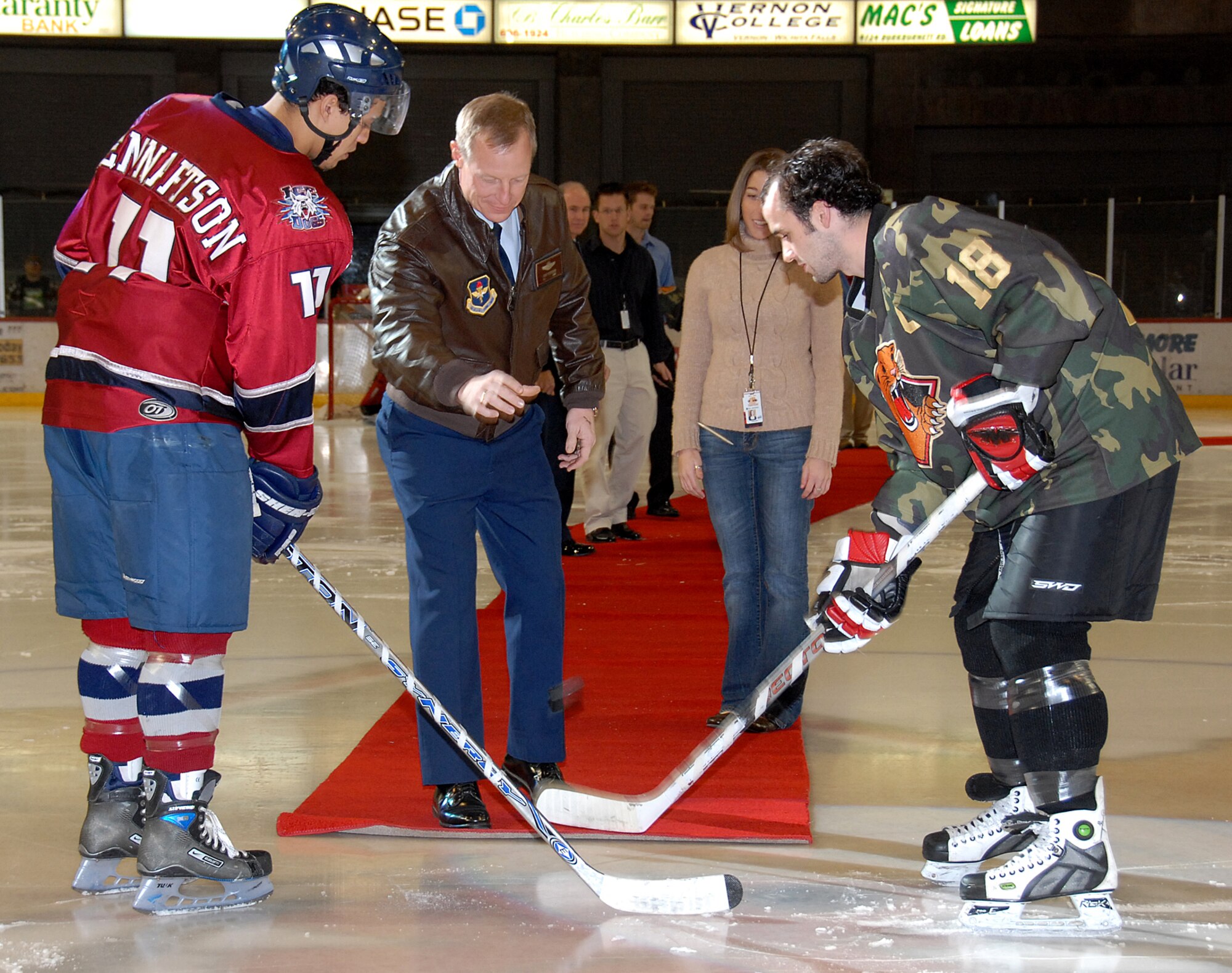 Col. Dave Petersen, center, 80th Flying Training Wing commander, drops the puck to begin the military appreciation hockey game between the Wichita Falls Wildcats and the Fairbanks Ice Dogs. Also pictured is Ice Dogs forward John Lennartson, left, and Wildcats forward Adam Cardwell. Fairbanks won the game, 4-3. (U.S. Air Force photo/Mike Litteken)