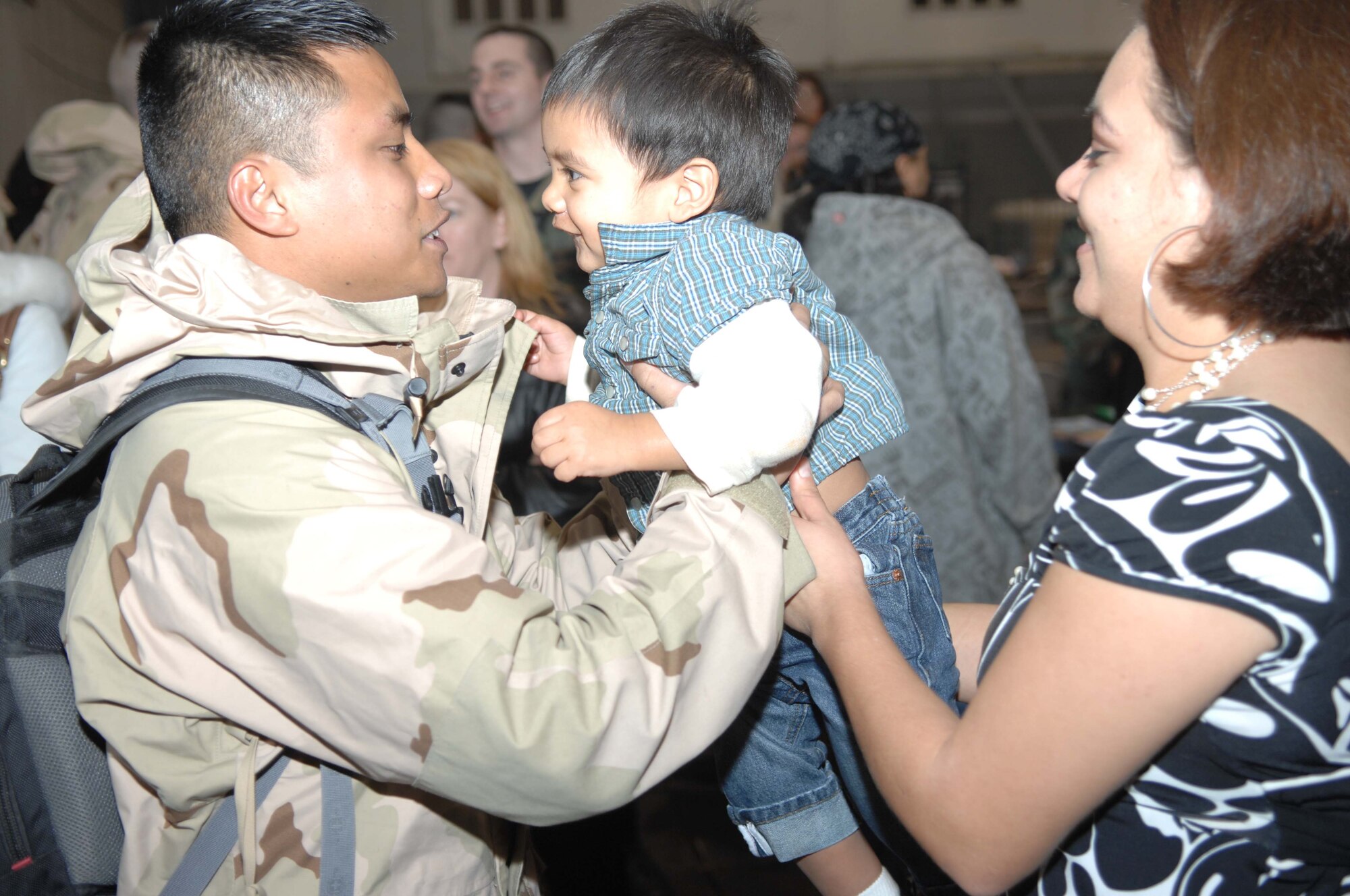 Senior Airman Mark Christy, 7th Munitions Squadron, greets his 19-month old son, Kai, and his wife, Roxane, after a six month deployment. Airman Christy was part of a 300-person deployment to Southwest Asia. (U.S. Air Force photo by Airman 1st Class Jennifer Romig)