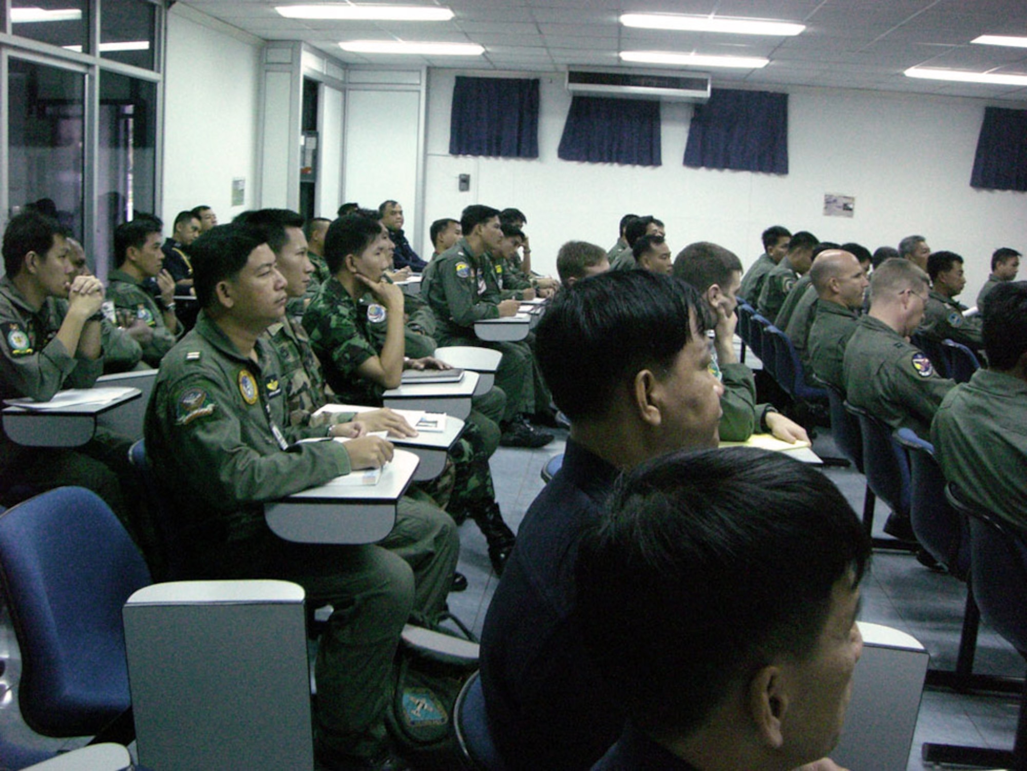 Pilots and aircrew of the Air Force, Marines, Royal Thai air force and the Republic of Singapore air force review the initial Cope Tiger 2008 daily flying operations briefing Jan. 27 at Korat Royal Air Base, Thailand. Cope Tiger is a multilateral joint and combined field training and humanitarian and civic assistance exercise involving Thailand, Singapore and the United States. The Thai-, Singaporean- and U.S.-hosted exercise enhances combined readiness and interoperability, reinforces U.S. commitment to the Southeast Asian region, and demonstrates the U.S. capability to project combined and joint forces strategically in a multilateral environment. (U.S. Air Force photo/Capt. Renee Lee) 

