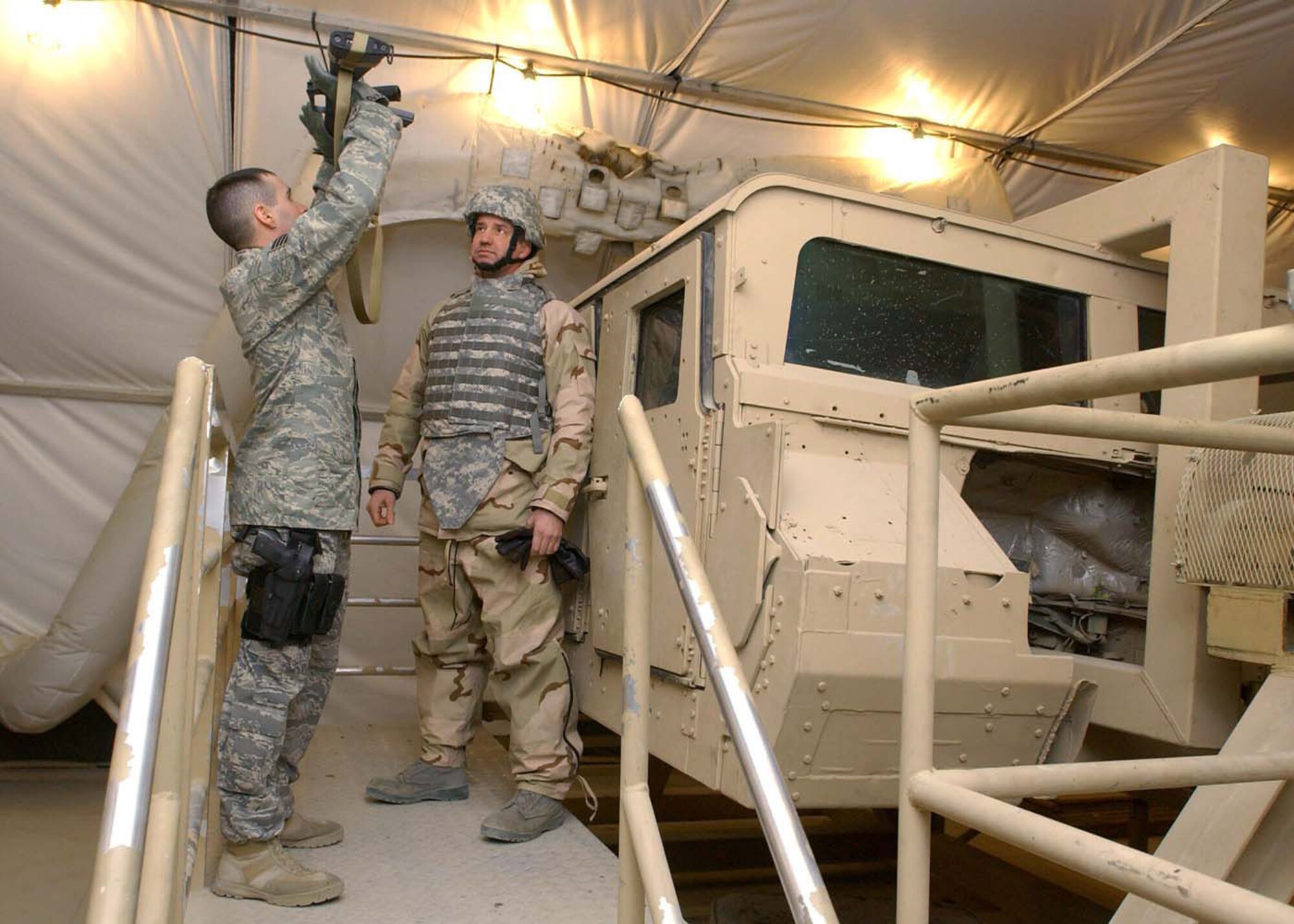 Staff Sgt. Michael DeJesus shows Tech. Sgt. Aaron Sholar how to balance while upside down with his weapon during Humvee Egress Rollover Training. The training teaches Airmen how to exit a humvee in water or at night while the vehicle is upside down. Sergeant DeJesus is the 455th Expeditionary Security Forces Squadron NCO in charge of physical security and his home unit is the 88th Security Forces Squadron, Wright-Patterson Air Force Base, Ohio, and Sergeant Sholar's is the 90th Aircraft Maintenance Unit at Elmendorf AFB, Alaska. (U.S. Air Force photo/Master Sgt. Demetrius Lester) 