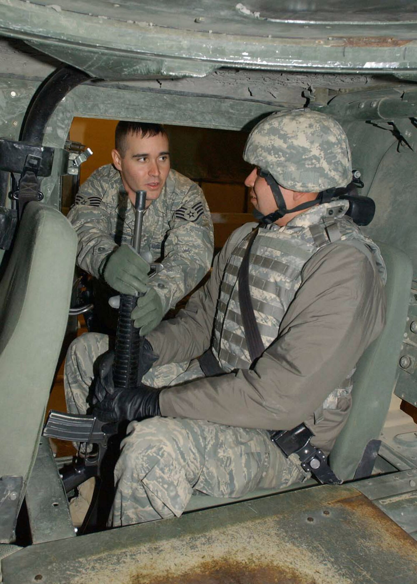 Staff Sgt. Michael DeJesus instructs Staff Sgt. Morris Ned on how to hold a weapon while in a convoy during Humvee Egress Rollover Training. The training teaches convoy members how to egress after a rollover. Sergeant DeJesus is the 455th Expeditionary Security Forces Squadron NCO in charge of physical security and his home unit is the 88th Security Forces Squadron, Wright-Patterson Air Force Base, Ohio, and Sergeant Morris, a 455th Expeditionary Security Forces force protection escort, is deployed from the 81st Communications Squadron, Keesler AFB, Miss. (U.S. Air Force photo/Master Sgt. Demetrius Lester) 