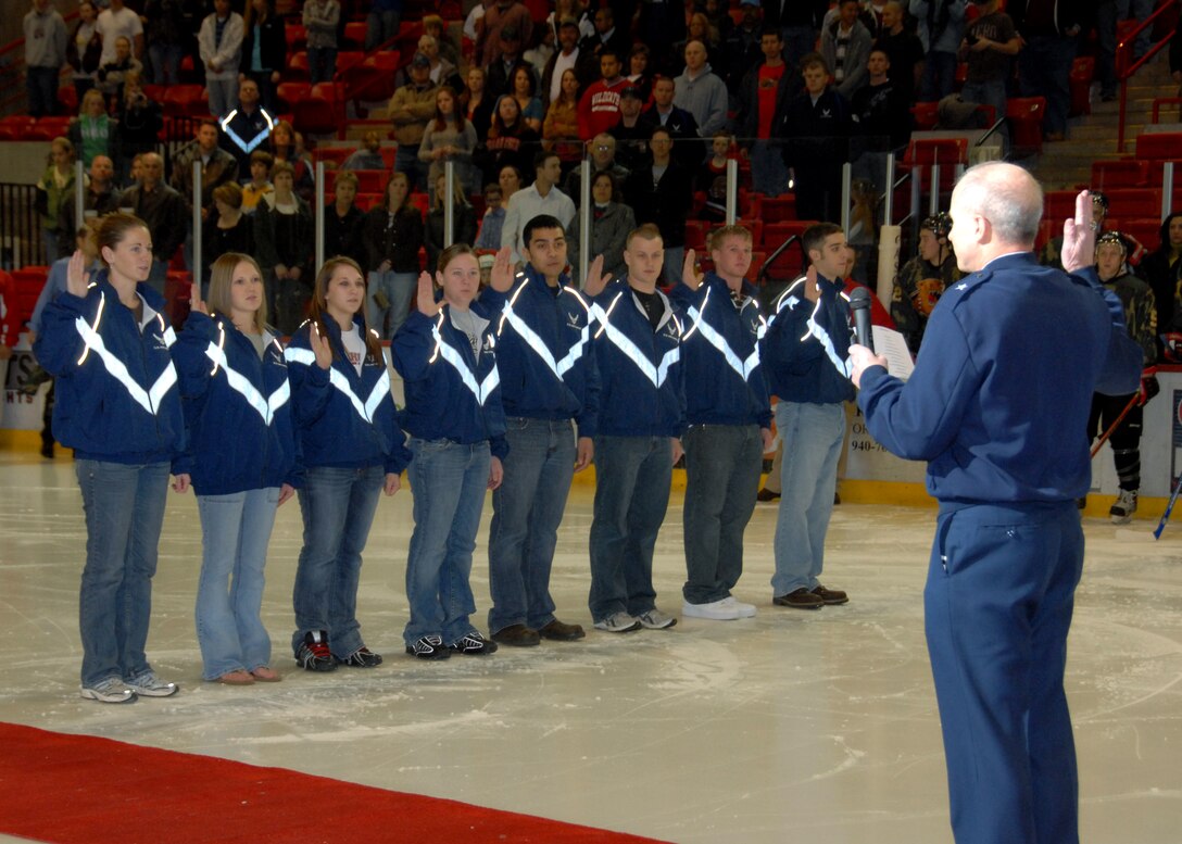 Brig. Gen. Richard Devereaux, right, commander of the 82nd Training Wing at Sheppard Air Force Base, Texas, guides some of the newest Air Force recruits through the oath of enlistment Jan. 26 before a Wichita Falls Wildcats hockey game at Kay Yeager Coliseum. The enlistees came from Wichita Falls-area high schools. (U.S. Air Force photo/Mike Littken)