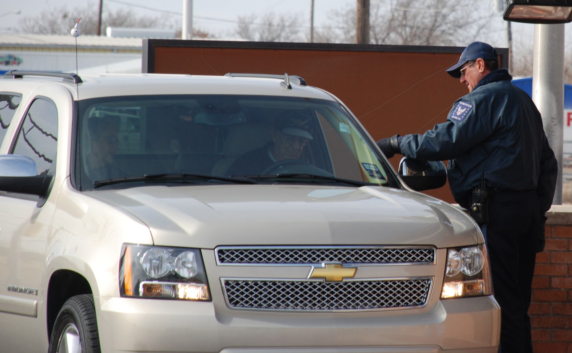 Michael Collins, right, checks the identification of a motorist entering through the Missile Road Gate Jan. 25. Mr. Collins, a contract security guard with Complete Security Concepts, identified invalid licenses for workers attempting to enter Sheppard Jan. 25. Six employees of a subcontractor were detained and turned over to the Wichita Falls Police Department. (U.S. Air Force photo/Airman 1st Class Jacob Corbin)