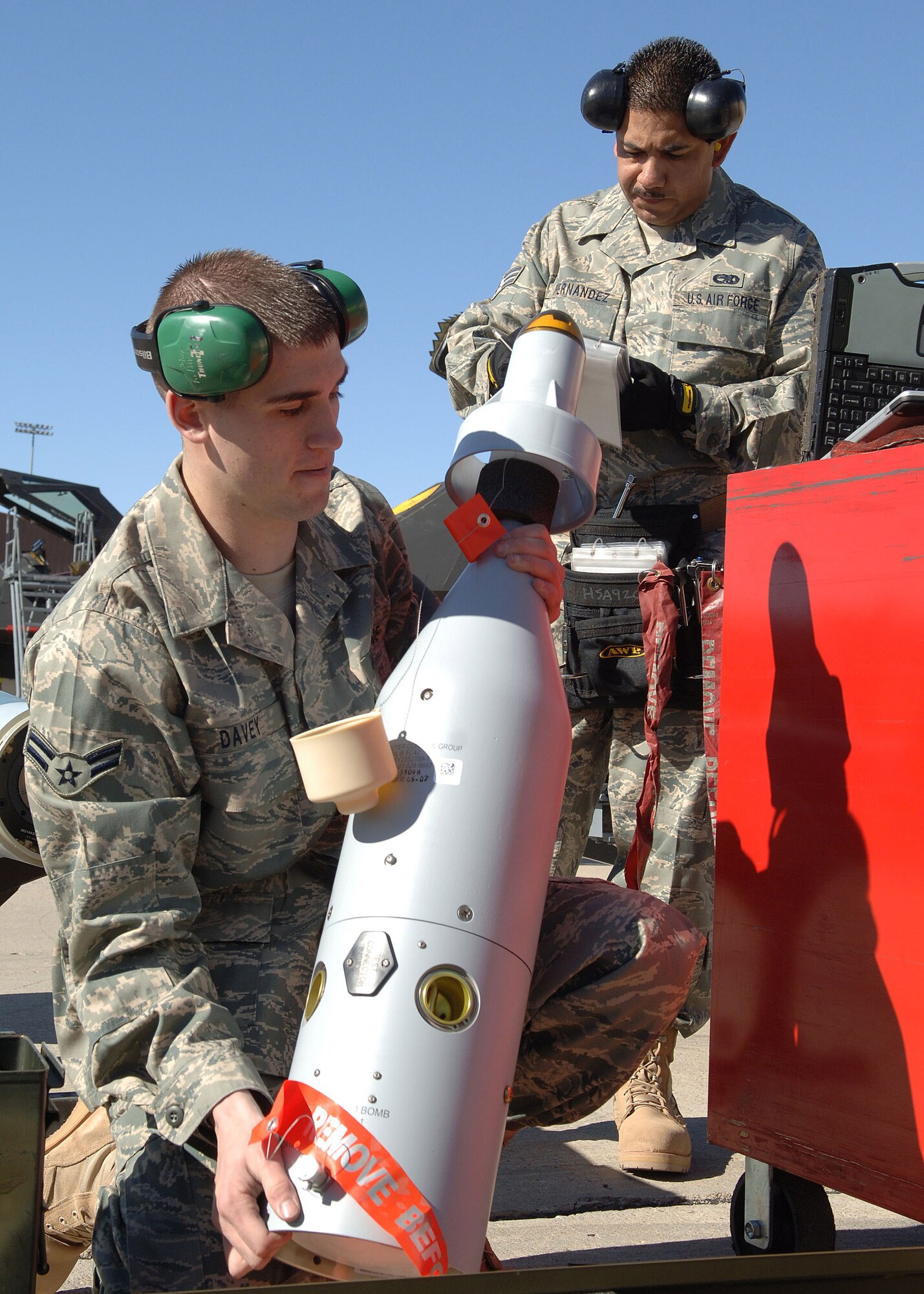 Airman 1st Class Kyle Davey and Senior Airman Ignacio Hernandez prepare a guided bomb unit-12 for load the F-117 Nighthawk Weapons Load Crew of the Year Competition Jan. 18 at Holloman Air Force Base, N.M. The competition is the last of its kind for the F-117. Airmen Davey and Hernandez are assigned to the 49th Aircraft Maintenance Squadron. (U.S. Air Force photo/Airman 1st Class John D. Strong II) 
