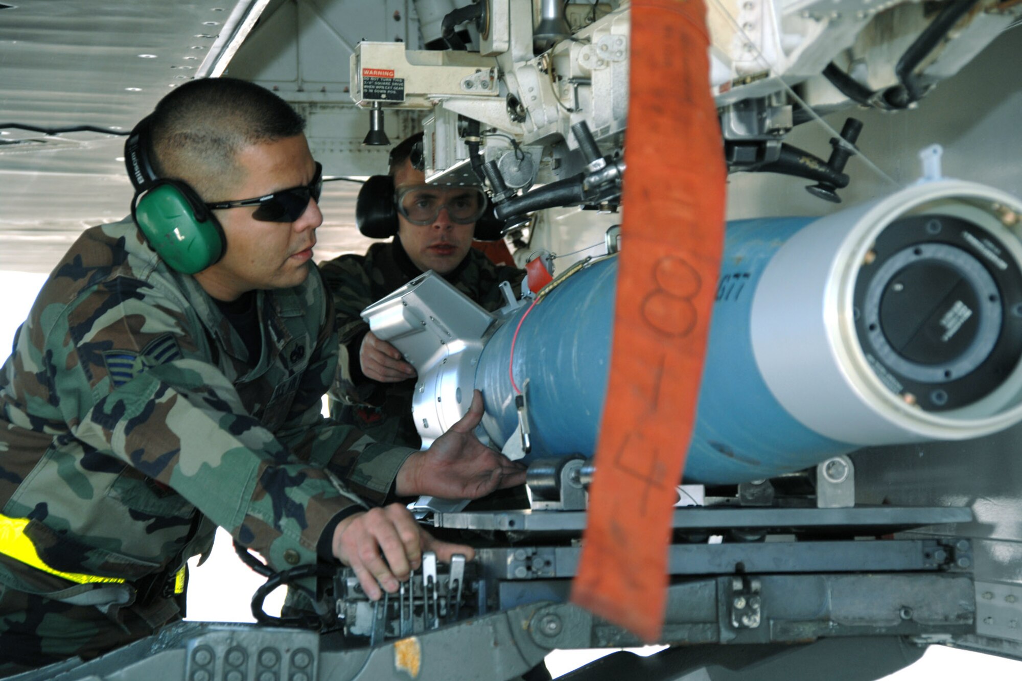 Staff Sgt. Alberto Vazquez and Senior Airman Adam Evans load a guided bomb unit-12 during the  F-117 Nighthawk Weapons Load Crew of the Year Competition Jan. 18 at Holloman Air Force Base, N.M. Seargent Vazquez, Airman Evans and teammate, Airman 1st Class Ray Wornat, represented the 8th Aircraft Maintenance Unit during the competition. (U.S. Air Force photo/Airman 1st Class Jamal D. Sutter) 