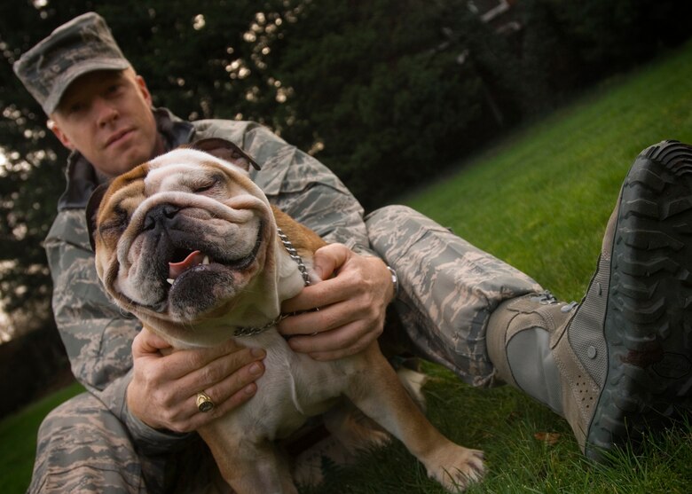 Command Chief Master Sgt. Michael Warner, 100th Air Refueling Wing, explains how his English bulldog, Achilles, squints his eyes tight and shakes his head and tail when greeting a potential new friend, Jan. 25, 2008.