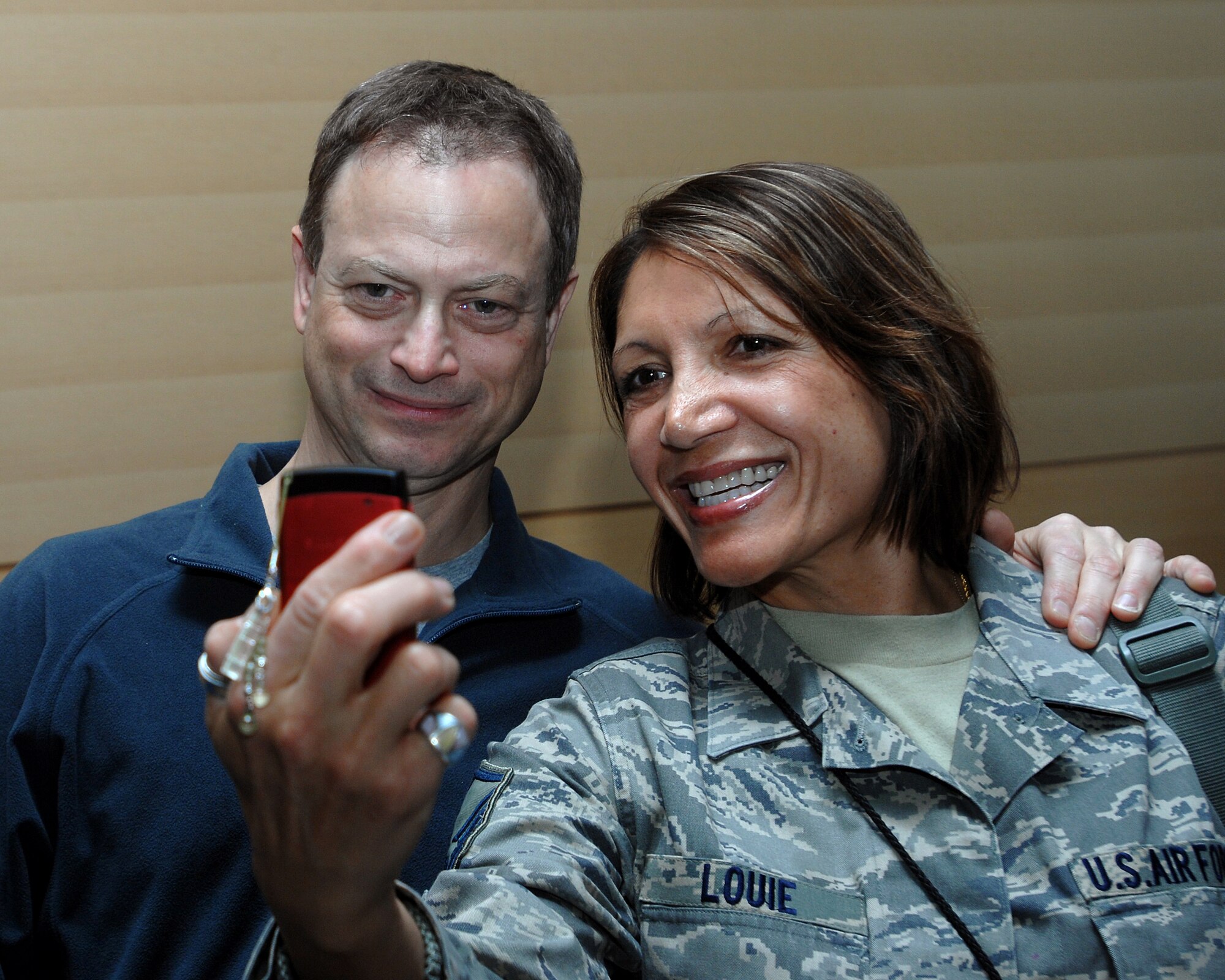 Master Sgt. Jeannette Louie takes her own portrait with movie and TV star actor Gary Senise during his recent visit to Ramstein Air Base Jan. 25. Gary Sinise and friends, Medal of Honor recipients Mike Thornton and Drew Dix, and actor John Ratzenberger visited Ramstein to help boost morale and say thanks for all the great work accomplished by the armed forces. (U.S. Air Force photo/Airman 1st Class Kenny Holston)