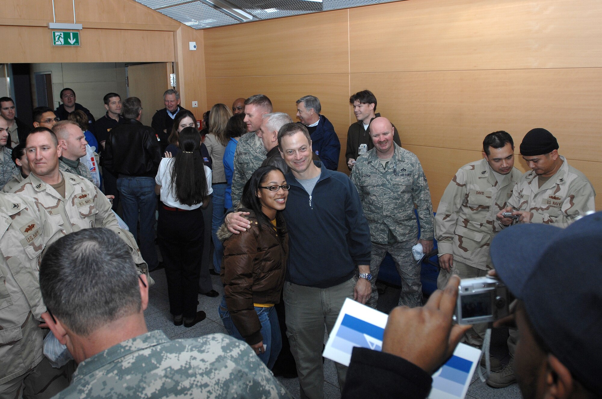 Actor Gary Senise was the center of attention Jan. 25 at the Ramstein Passenger Terminal. Soldiers, Sailors and Airman where excited to meet the star actor and wasted no time getting autographs and taking photos with him. In this photo Gary sinise poses for a picture with airman 1st Class Nikol Brown, and a large group of Airmen, Soldiers and Sailors. He and Medal of Honor recipients Mike Thornton and  Drew Dix,  and actor John Ratzenberger visited Ramstein Air Base to help boost morale and say thanks for all the great work accomplished by the armed forces. (U.S. Air Force photo/Airman 1st Class Kenny Holston)