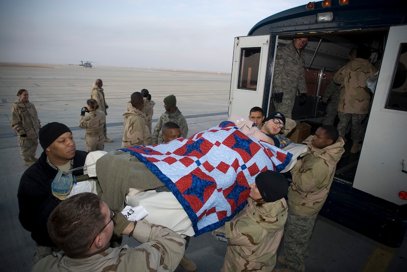 BALAD AIR BASE, Iraq -- Army Pfc. William McClellan, an injured member of the 2nd Infantry Division, is unloaded from a Contingency Aeromedical Staging Facility aeromedical evacuation bus on the flight line here before departing for Regional Medical Center Landstuhl, Germany. The CASF employs volunteers to assist with the loading and unloading of patients on litters. Private McClellan is deployed from Fort Lewis, Wash. (U.S. Air Force photo/ Master Sgt. John Nimmo, Sr.) 