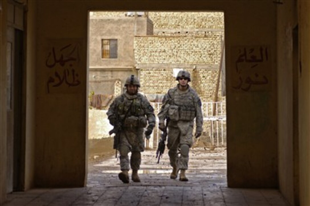Two U.S. Army soldiers are framed by a doorway as they enter a building during a routine patrol in Khatun, Iraq, on Jan. 24, 2008.  Soldiers from Bravo Company 1st Battalion, 38th Infantry Regiment, 4th Stryker Brigade Combat Team, 2nd Infantry Division are patrolling the streets of Khatun to provide security.  