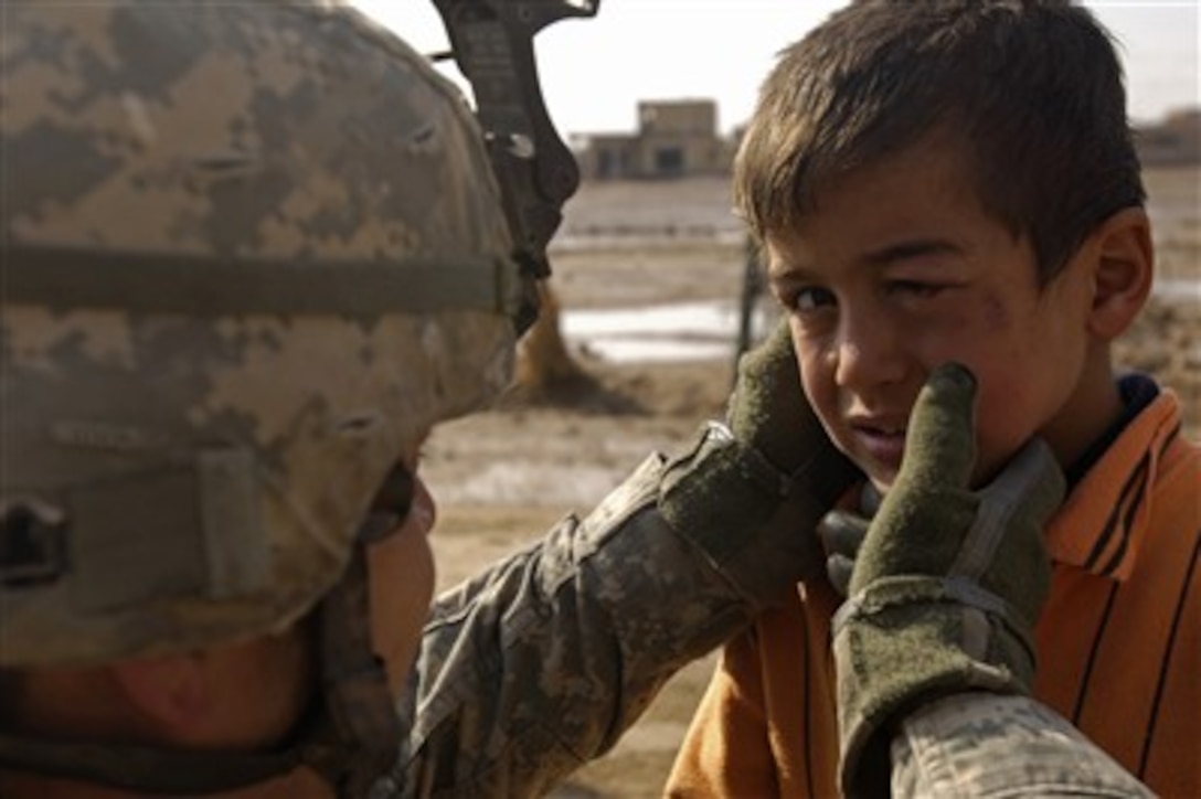U.S. Army Spc. Miguel Sevilla examines an Iraqi boy's black eye during a routine patrol in Khatun, Iraq, Jan. 24, 2008.  Soldiers from Bravo Company 1st Battalion, 38th Infantry Regiment, 4th Stryker Brigade Combat Team, 2nd Infantry Division are patrolling the streets of Khatun to provide security.  