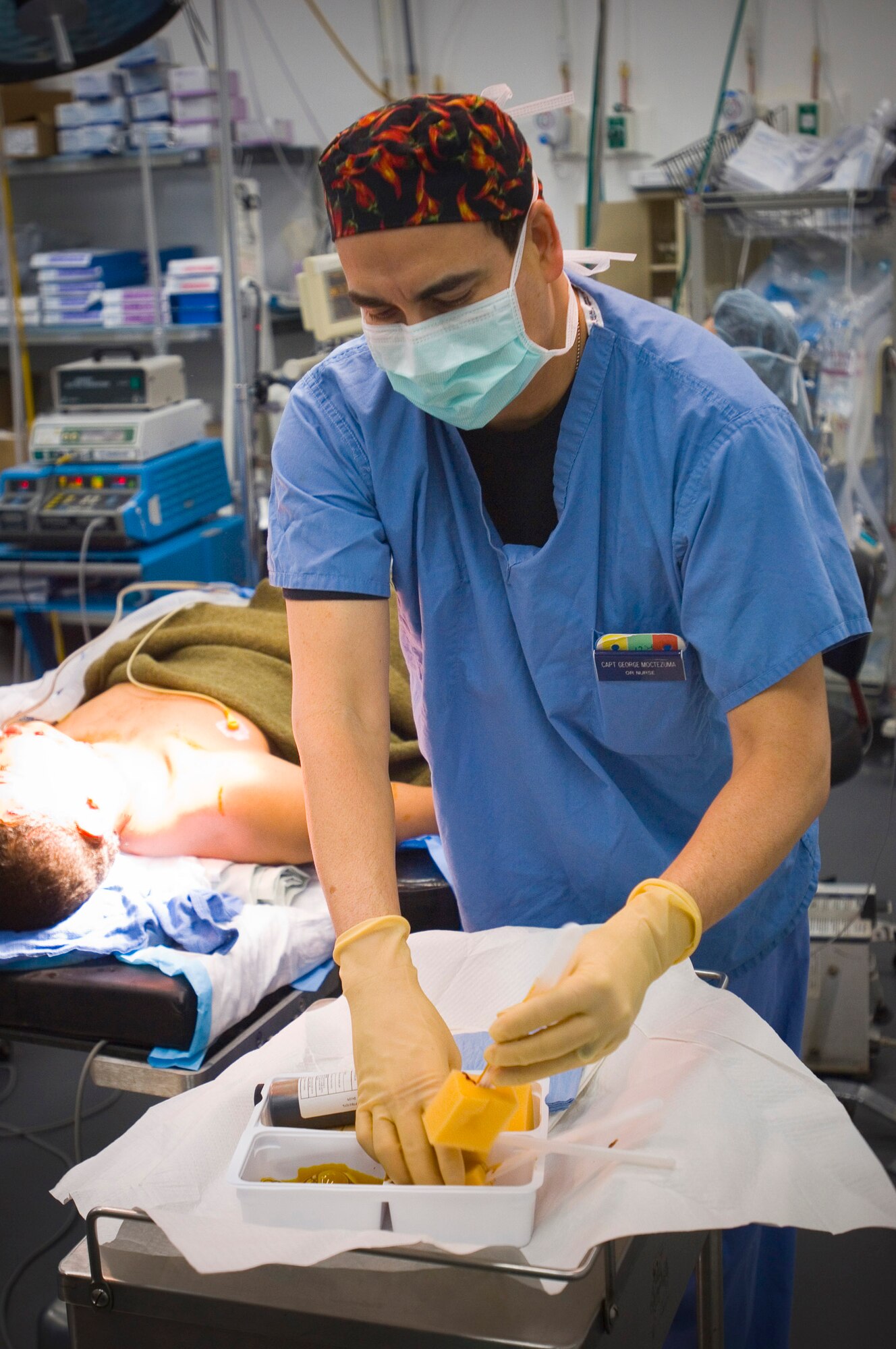 Capt. George Moctezuma, an operating room nurse, prepares to scrub a wounded patient before a surgical procedure Dec. 28 at the Air Force Theater Hospital at Balad Air Base, Iraq. Captain Moctezuma received his degree in nursing as an enlisted medic and worked as a civilian nurse in his off-duty time before earning his commission. Captain Moctezuma is deployed from Wilford Hall Medical Center, San Antonio, Texas. (U.S. Air Force photo/Tech. Sgt. D. Clare) 