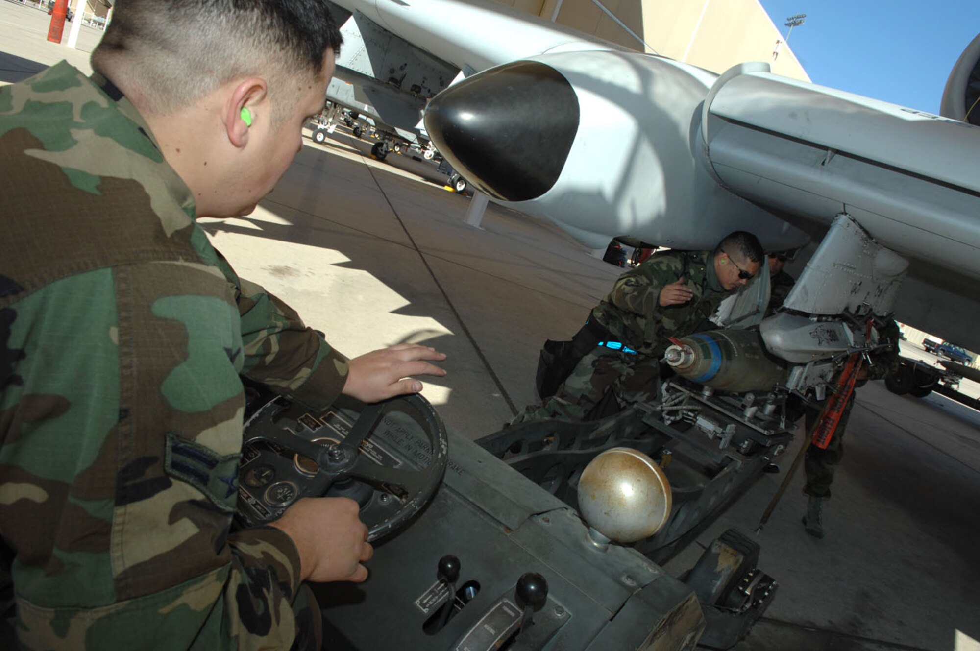 Airman 1st Class Devin Macneil, Staff Sgt. Anthony Walker, and Senior Airman Robert Morales, all weapons load crew chiefs from the 358th Aircraft Maintenance Unit, work together to load an MK-82 to an A-10 during the Load Crew of the Year competition Jan. 25. The 358th AMU competed against two other load crew teams on efficiently loading six MK-82s and one AIM-9, and they were also evaluated in three different categories; a written test, dress and appearance, and their composite tool kit. (U.S. Air Force photo by Senior Airman Christina D. Kinsey)