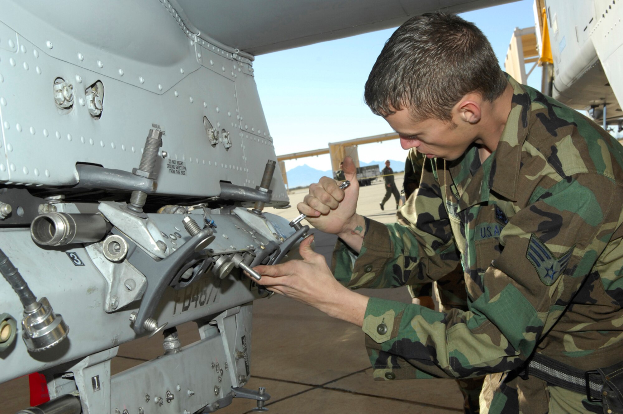 Senior Airman Christopher Redmond, 355th Aircraft Maintenance Squadron weapons loader, carefully prepares to secure an MK-82 on to an A-10 during the load crew portion of Davis-Monthan's Annual Load Crew Competition Jan. 25. The load team was graded on their ability to quickly and efficiently load six MK-82s and one AIM-9. (U.S Air Force photo by Senior Airman Jesse Shipps)