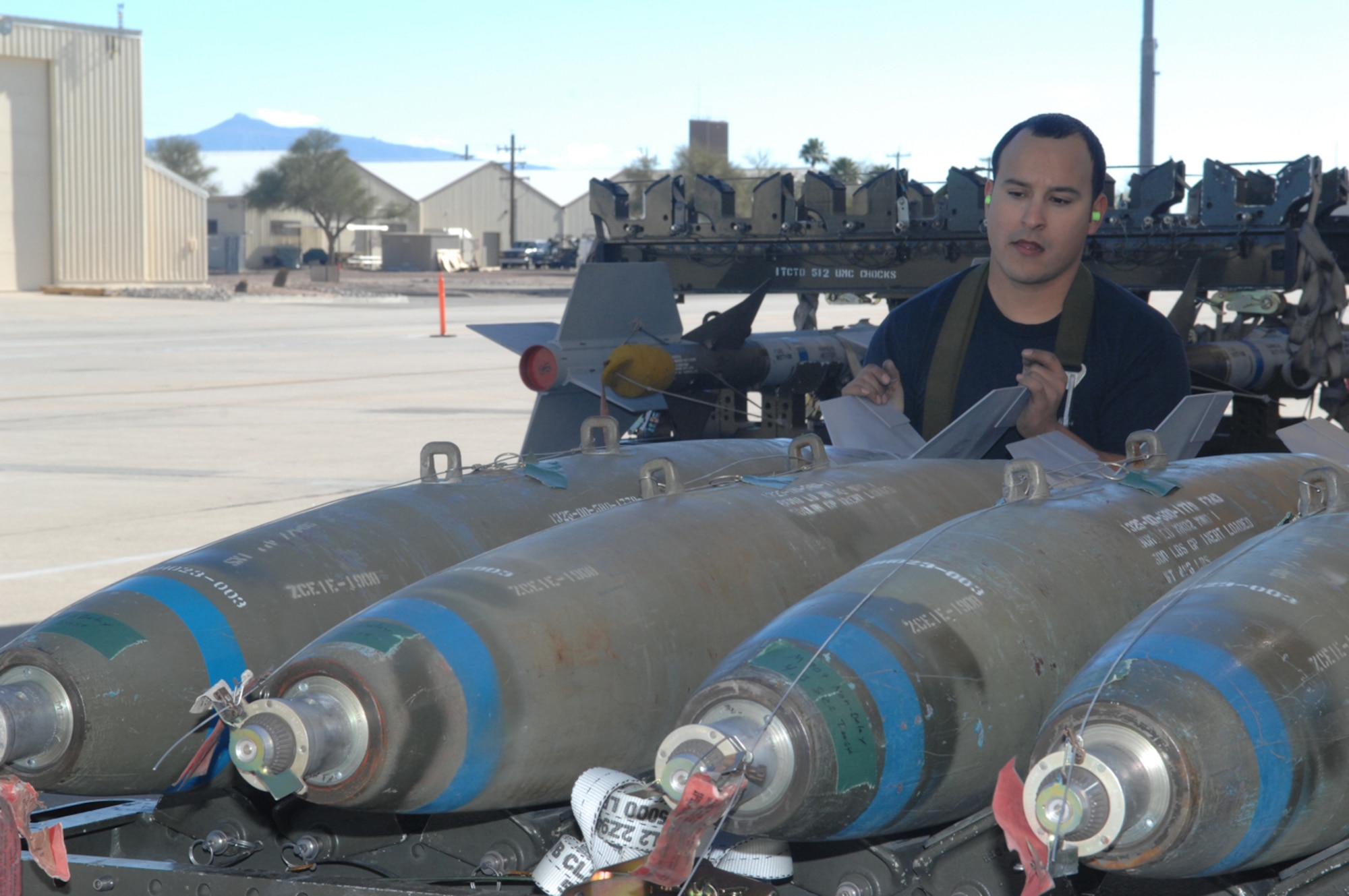 Staff Sgt. Demencio Solorzano, 354th Aircraft Maintenance Unit, guides a teammate to load a bomb during the weapons load crew competition Jan. 25 here. Three load crew teams competed in the yearly competition. Winners will be announced at the 2008 Maintenance Professional of the Year. (U.S. Air Force photo by Airman 1st Class Melissa T. Copeland)