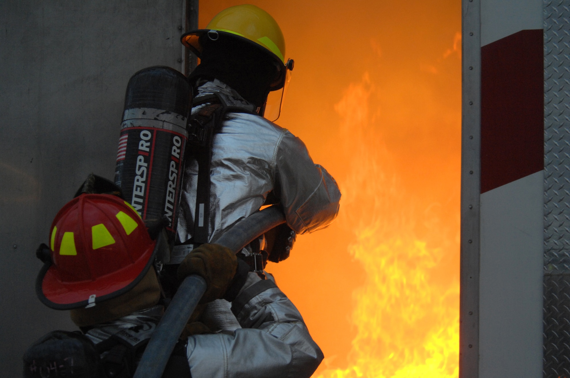 Colonel Kent Laughbaum, 355th Fighter Wing commander, (top) along with Capt. Michael Reilly, 355th Civil Engineer Squadron, put out a fire during a training exercise with the D-M Fire Department here, January 23. (U.S. Air Force photo/Airman 1st Class Noah R. Johnson)