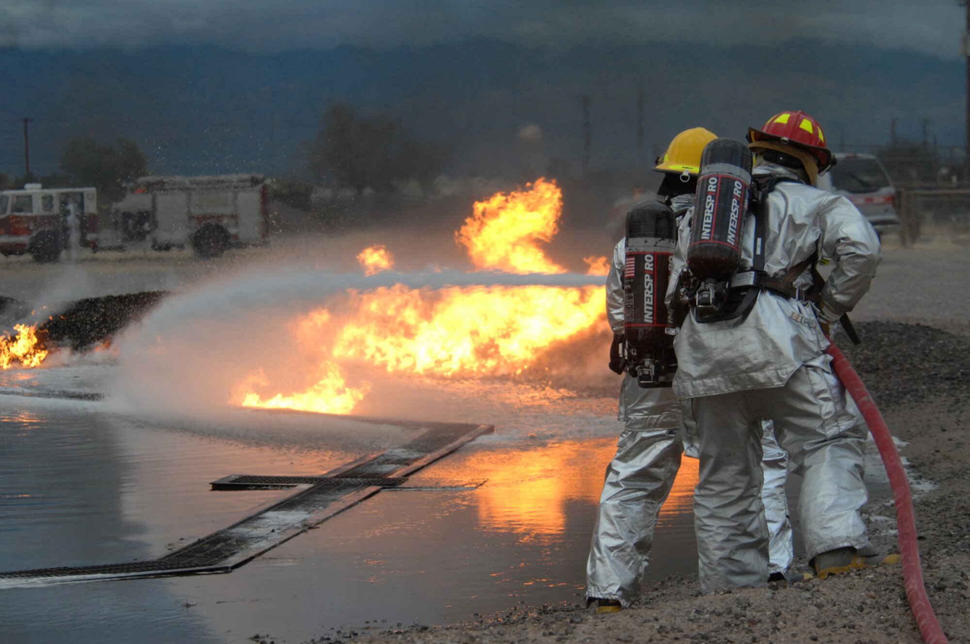 Colonel Kent Laughbaum, 355th Fighter Wing commander, (left) along with Staff Sgt. Michael Long, 355th Civil Engineer Squadron, put out a fire during a training exercise with the D-M Fire Department here Jan. 23. Colonel Laughbaum spent the afternoon as an honorary fireman. (U.S. Air Force photo byAirman 1st Class Noah R. Johnson)