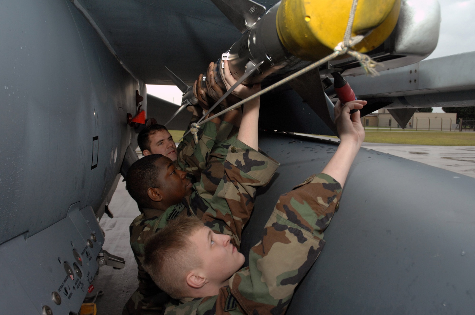 Staff Sgt. Ryan Bloom, Senior Airman Jessie Speed and Airman 1st Class Kevin Hoffnagle load a CAP-9 missile onto an F-15E Strike Eagle Jan. 17at Royal Air Force Lakenheath, England. The Airmen are assigned to the 48th Aircraft Maintenance Squadron (U.S. Air Force photo/Airman 1st Class John Easterling) 
