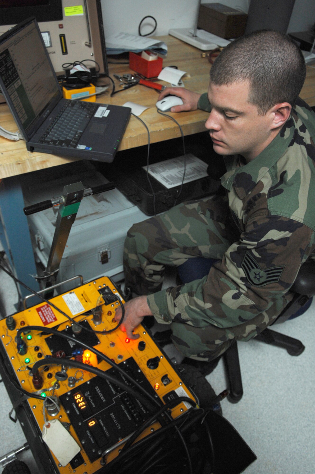 NELLIS AIR FORCE BASE, Nev.—Staff Sgt. Thomas McKrush, 57th Component Maintenance Squadron, precision measuring equipment laboratory craftsman, verifies the proper air speed and altitude pressure outputs are set correctly for the testing of various aircraft here Jan. 28. The PMEL shop is responsible for making sure all equipment needed to perform Nellis' mission is correctly aligned, measured, and calibrated. (U.S. Air Force photo by Senior Airman Nadine Y. Barclay)
