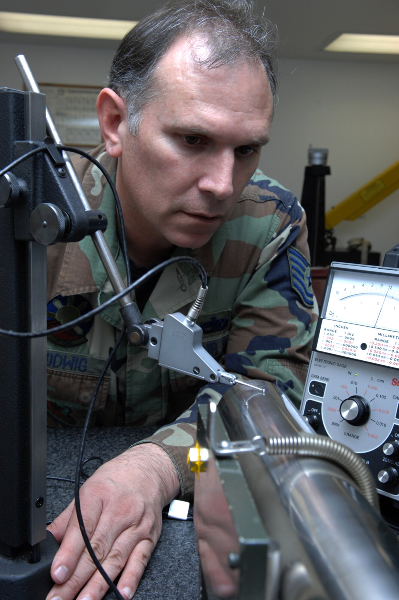 NELLIS AIR FORCE BASE, Nev.—Tech. Sgt. Terry Ludwig, 57th Component Maintenance Squadron, precision measuring equipment laboratory craftsman, checks an F-16 Falcon’s targeting navigational pod to ensure there are no deficiencies present here Jan. 28. The PMEL shop is responsible for making sure all equipment needed to perform Nellis' mission is correctly aligned, measured, and calibrated. (U.S. Air Force photo by Senior Airman Nadine Y. Barclay)