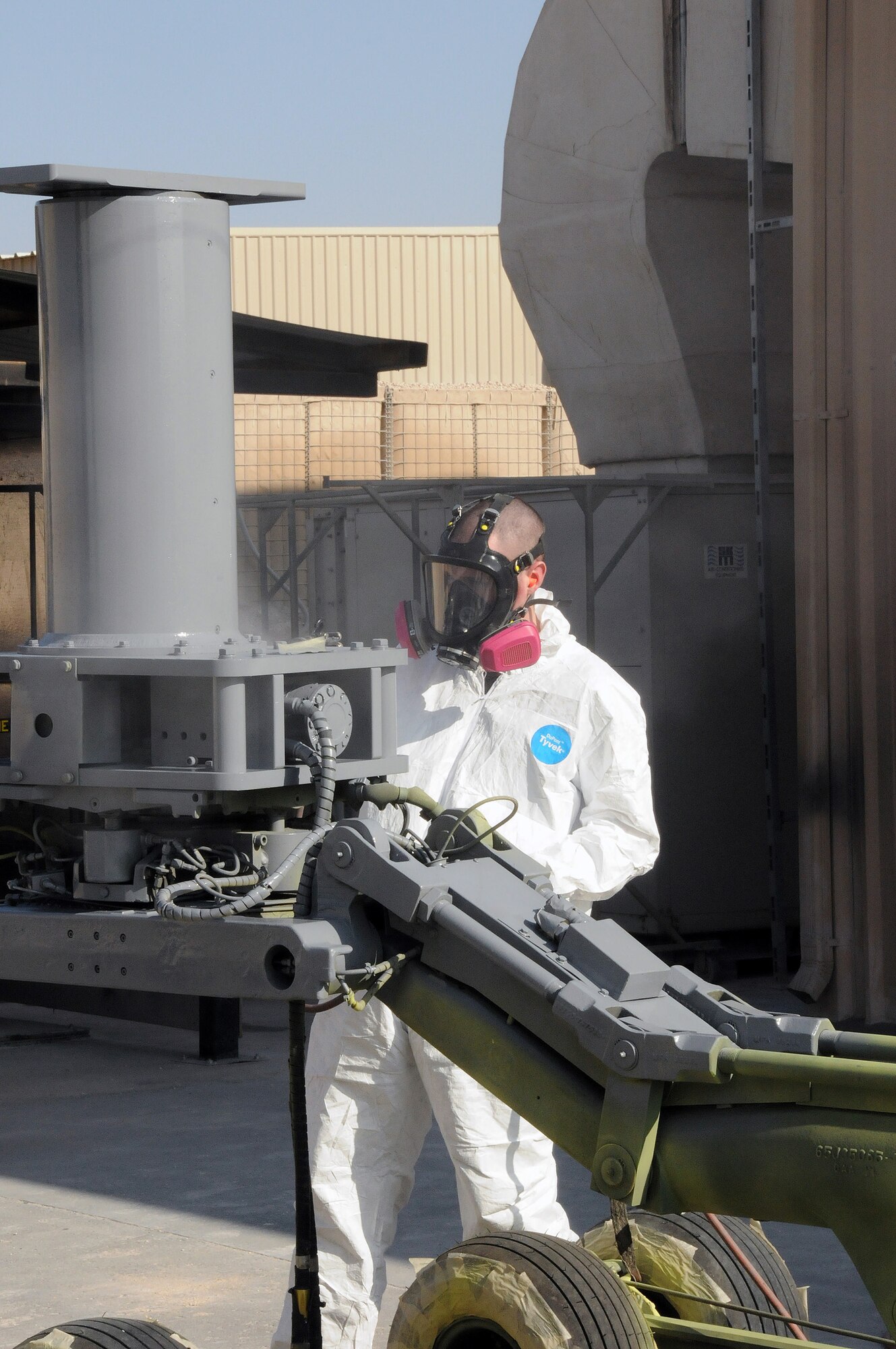 Senior Airman Geoffrey Sorensen from the 379th Expeditionary Maintenance Squadron, Fabrication Flight, Sheet Metal shop, paints a bomb lift Jan. 29. Every five to six years the bomb lifts have to be repainted in order to prevent corrosion.  Airman Sorensen is deployed from Hill Air Force Base, Utah.  (U.S. Air Force photo/Senior Airman Domonique Simmons)