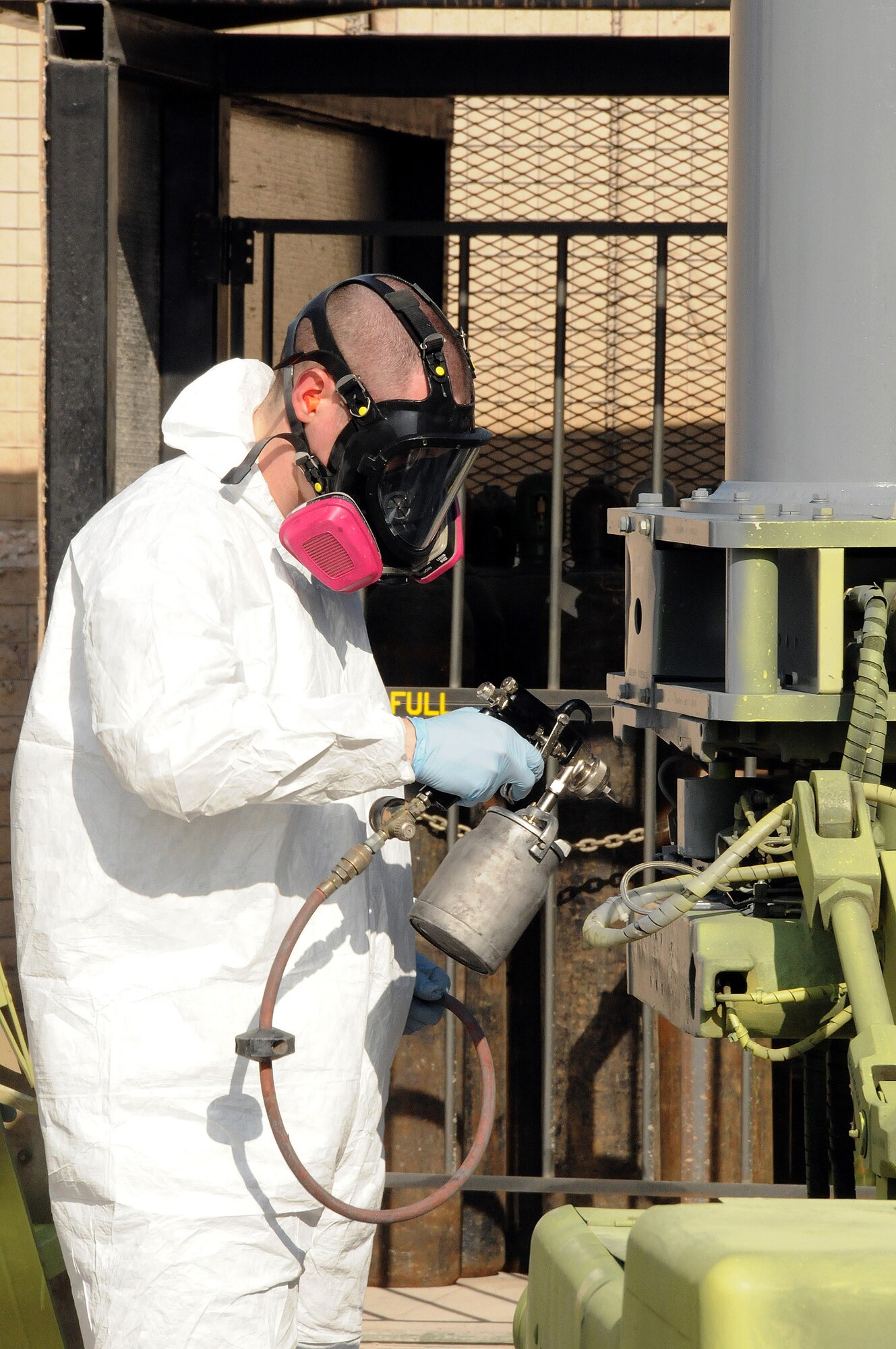 Senior Airman Geoffrey Sorensen from the 379th Expeditionary Maintenance Squadron, Fabrication Flight, Sheet Metal Shop, paints a bomb lift Jan. 29. Every five to six years the bomb lifts have to be repainted in order to prevent corrosion.  Airman Sorensen is deployed here from Hill Air Force Base, Utah.  (U.S. Air Force photo/Senior Airman Domonique Simmons)