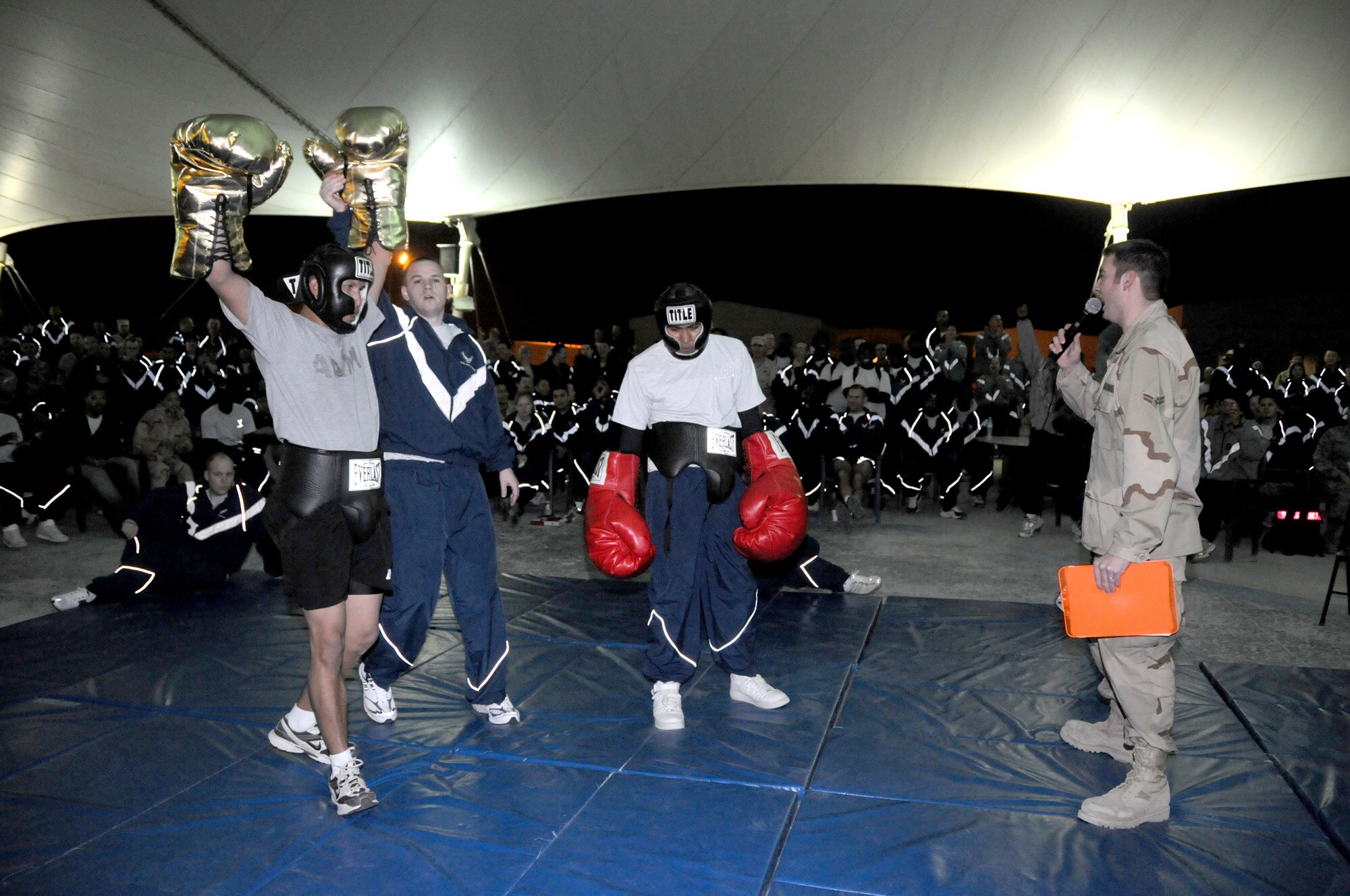 Airman First Class Jeremi Welborn, a member of the Desert 5, announces the champion of a boxing match that took place at Fight Night Jan. 25. The event took place in Memorial Plaza where approximately 1,000 servicemembers attended and enjoyed 15 boxing matches in all. (U.S. Air Force photo/Senior Airman Domonique Simmons)
