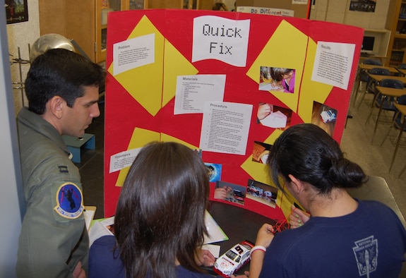 Capt. Rick Hiraldo, 84th Flying Training Squadron, observes as two Del Rio High School students describe how they created a vehicle fender that will repair itself and cause little or no damage to a vehicle after an accident during the school’s science fair Jan. 24. More than ten Laughlin members from various squadrons volunteered to judge the school’s annual science fair. (U.S. Air Force photo by Senior Airman Olufemi Owolabi)