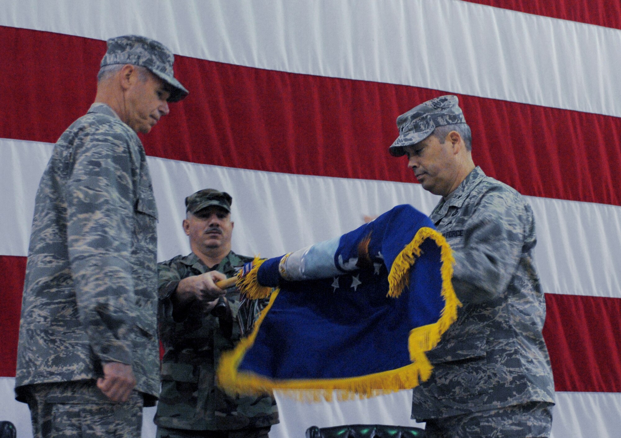 Maj. Gen. William Holland and Brig. Gen. Michael Longoria unfurl the wing's flag during an activation ceremony at Moody Air Force Base, Ga., Jan. 25. The new wing consolidates the tactical air control-party and battlefield weather specialties of the 3rd Air Support Operations Group at Fort Hood, Texas, the 18th ASOG at Pope AFB, N.C., and the specialized force protection capabilities of the 820th Security Forces Group at Moody AFB. General Holland is the 9th Air Force vice commander and deputy commander of U.S. Central Command Air Forces. General Longoria is the 93rd Air Ground Operations Wing commander. (U.S. Air Force photo/Senior Airman Angelita Lawrence)