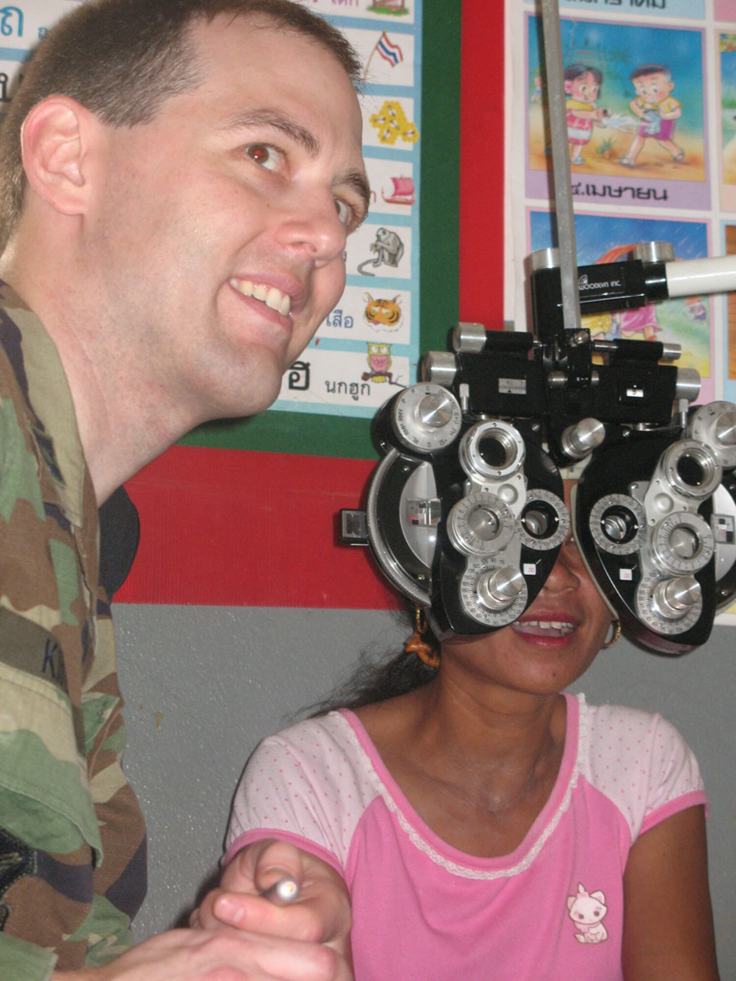 Capt. Wesley Kinerk, optometrist from Misawa Air Base, Japan, treats Sumnieng Jomgaklang at Ban Don Phawa School in a rural community outside of Korat, Thailand Jan. 29. Captain Kinerk is part of a medical team from Pacific Air Forces that's providing dental and medical care to Thais in the rural Korat areas during Exercise Cope Tiger, a multilateral joint and combined field training and humanitarian and civic assistance exercise involving Thailand, Singapore and the United States. The Thai-, Singaporean- and U.S.-hosted exercise enhances combined readiness and interoperability, reinforces U.S. commitment to the Southeast Asian region, and demonstrates U.S. capability to project combined and joint forces strategically in a multilateral environment. (U.S. Navy photo by MC3 AC Rainey)