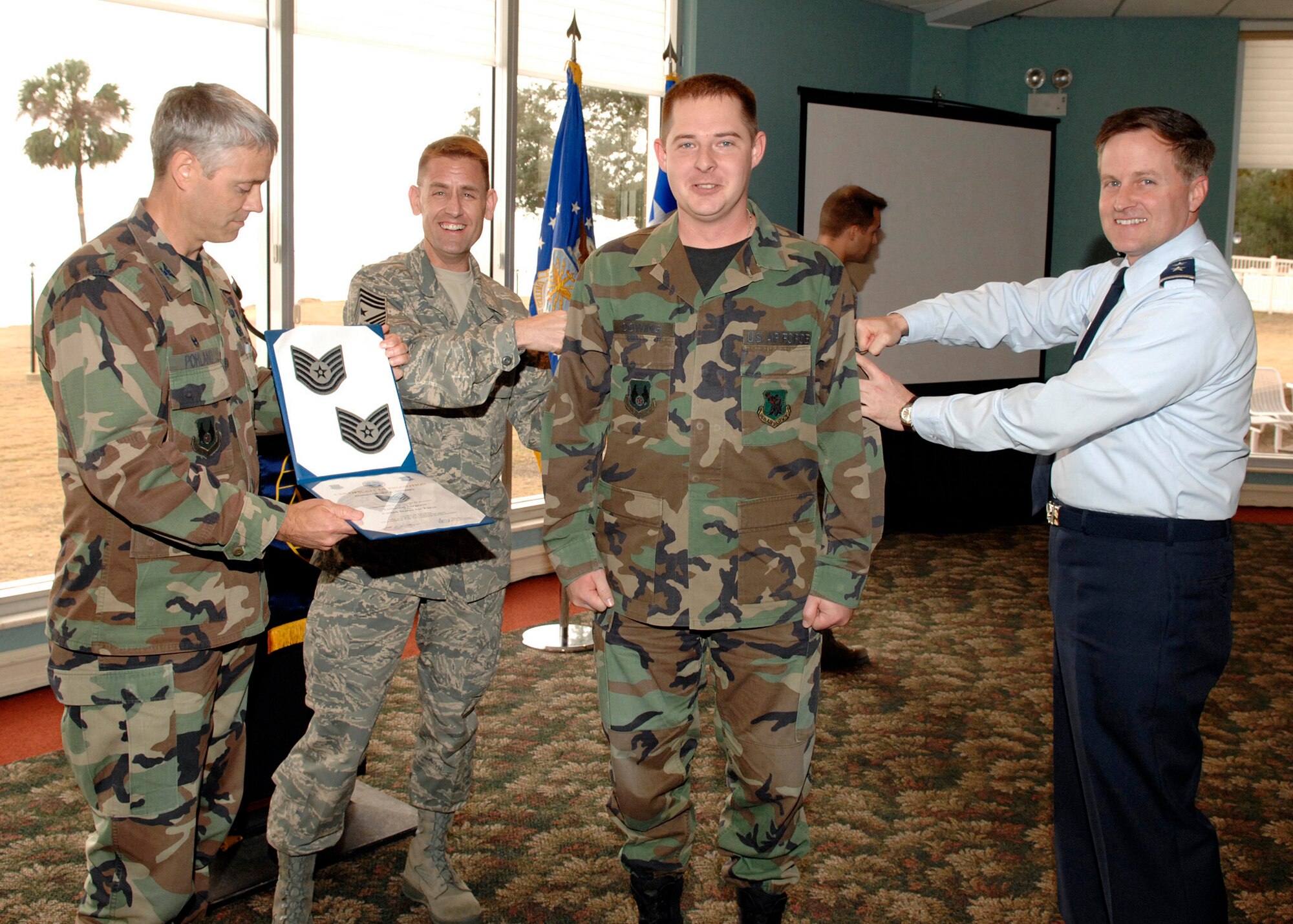 EGLIN AIR FORCE BASE, Fla. -- Col. Eric Pohland, 96th Air Base Wing commander, presents a Stripes for Exceptional Performers promotion to Tech. Sgt. Christopher Dowing, 96th Communications Squadron NCOIC of boundary protection, Jan. 17. Colonel Pohland was assisted by Maj. Gen. William Lord, Air Force Cyberspace commander, and Chief Master Sgt. Troy Engholm, 96th ABW command chief master sergeant. (U.S. Air Force photo by 1st Lt. Kristin M. Russell)