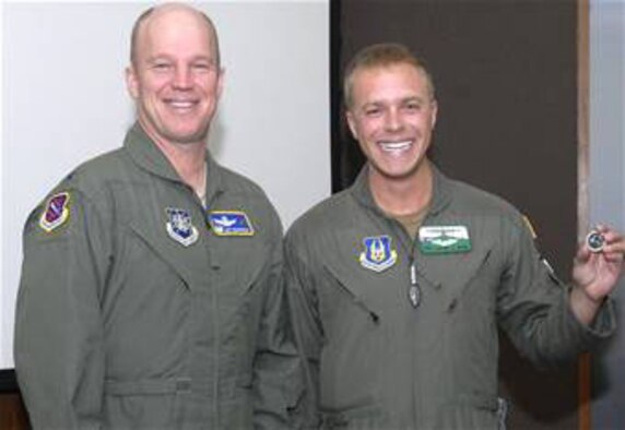 Tech. Sgt. Lamont Wood shows off his new commander's coin presented to him from Col. Jay Raymond, 21st Space Wing commander, on Jan. 28, 2008. Sergeant Wood, an Air Force Reservist assigned to the 731st Airlift Squadron, was awarded the coin for rendering aid to a young boy who was choking on a piece of ice at the base exchange in mid December. (U.S. Air Force photo/Mr. Rob Bussard)