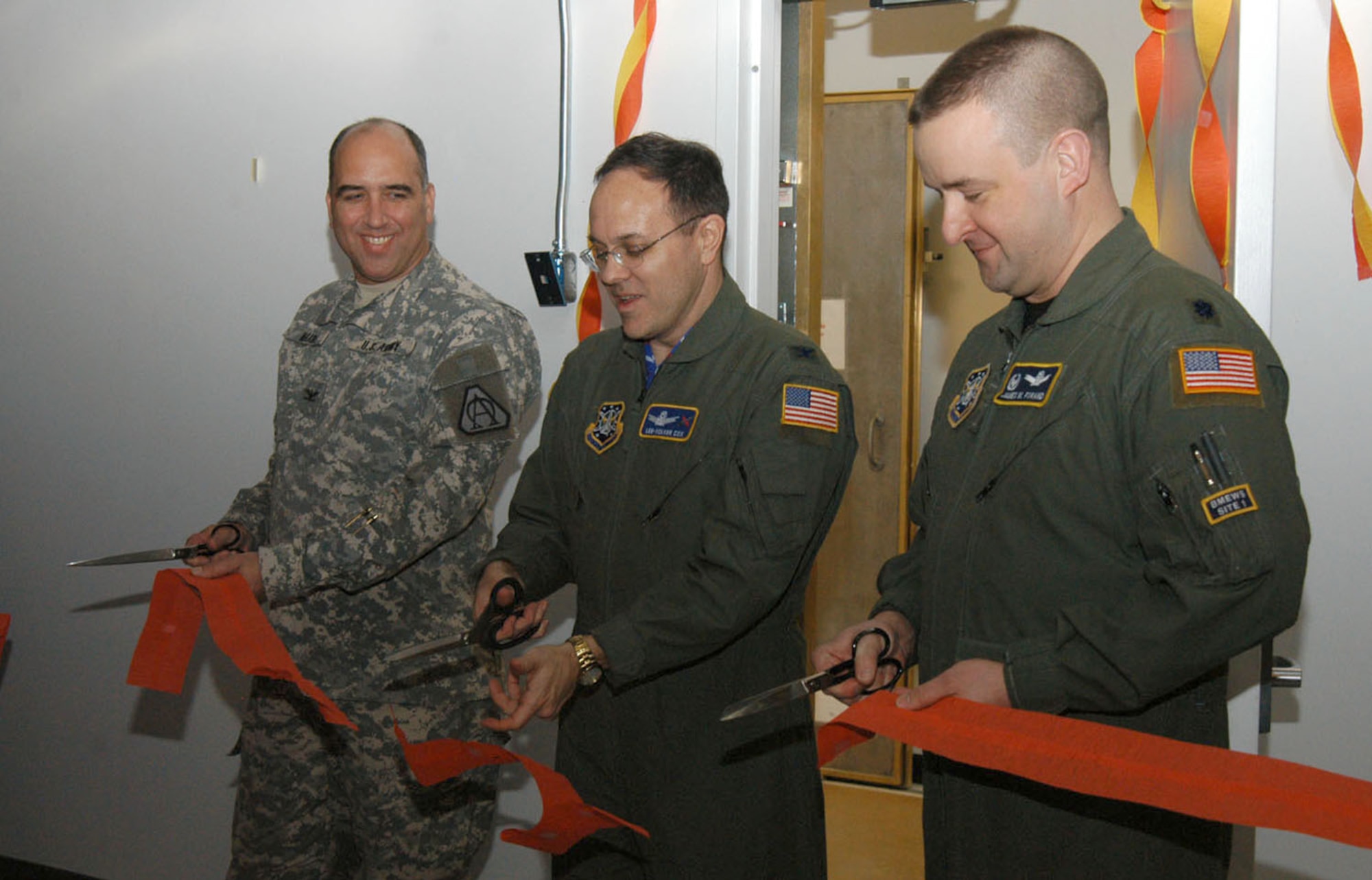 Col. Kyle Haase, Ballistic Missile Defense Systems Worldwide Deployments program manager, Col. Lee-Volker Cox, 821st Air Base Group commander, and Lt. Col. James Forand, 12th Space Weapon Squadron commander, cut the ribbon at a ceremony held at Thule Air Base, Greenland Jan. 24, marking the symbolic completion of the Upgraded Early Warning Radar construction phase and beginning of the equipment installation phase. The upgrade will consist of modifications to hardware and software that will provide detection and tracking of ballistic missiles launched toward North America and other nations, and is expected to be operational in late 2009 after extensive testing. (U.S. Air Force photo/1st Lt. Nicole Langley)