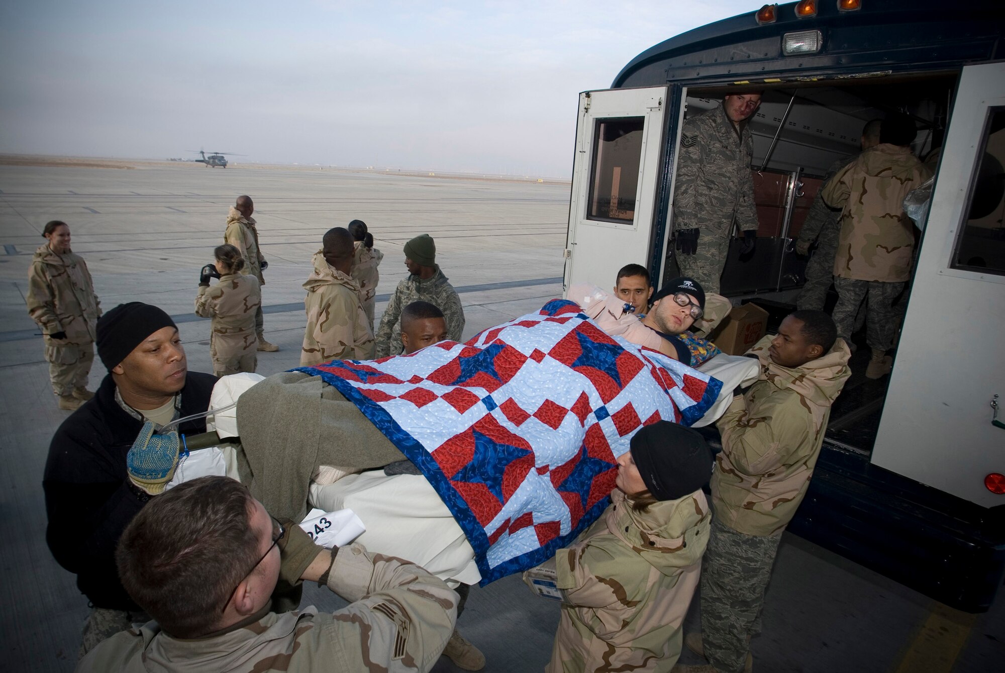 Army Pfc. William McClellan, an injured member of the 502nd Infantry Brigade, is unloaded from a Contingency Aeromedical Staging Facility bus on the Balad Air Base, Iraq, flight line Jan. 13 before departing for the Regional Medical Center Landstuhl, Germany. The CASF employs volunteers to assist with the loading and unloading of patients on litters. Private McClellan is deployed from Fort Campbell, Ky. (U.S. Air Force photo/Master Sgt. John Nimmo, Sr.)