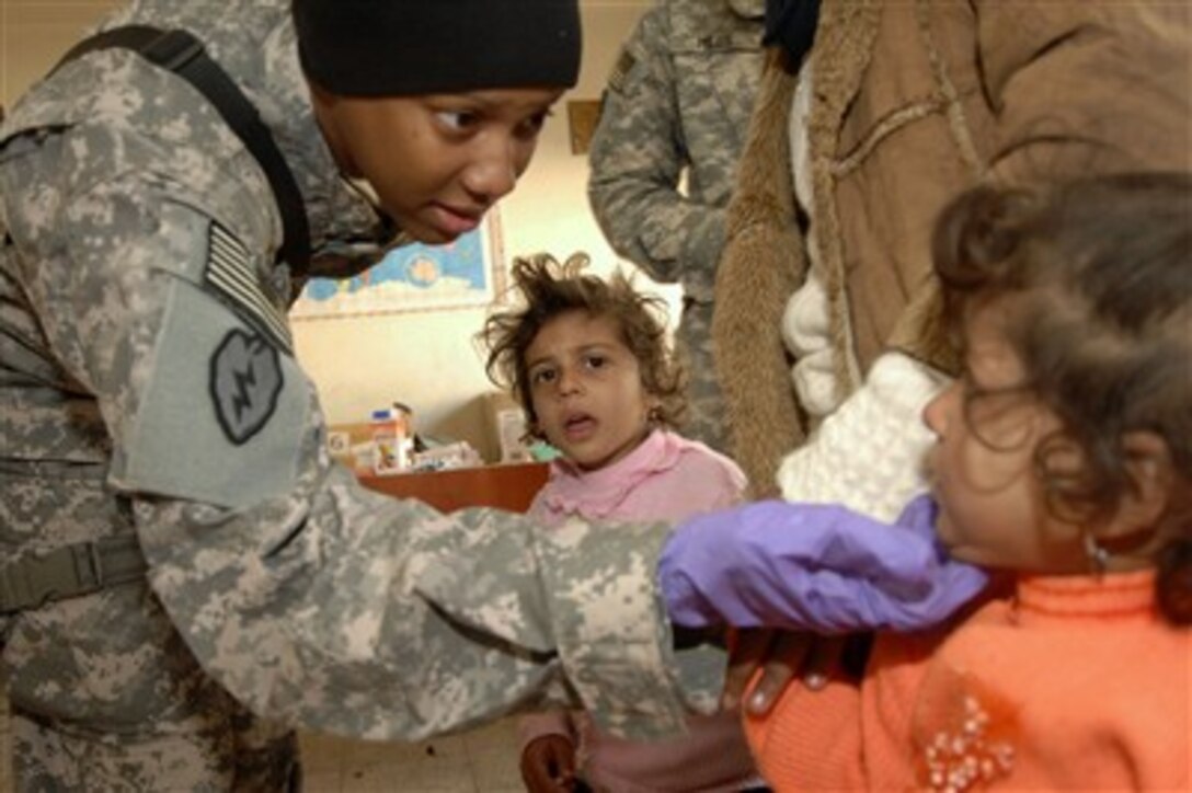 U.S. Army Capt. Yolanda Gray-Davis examines an Iraqi girl's cheek during a combined medical effort at Falahat Primary School in Hasan ad Daryush, Iraq, on Jan. 25, 2008.  Gray-Davis is a battalion surgeon from 1st Battalion, 143rd Field Artillery Regiment attached to the 2nd Stryker Brigade Combat Team, 25th Infantry Division.  