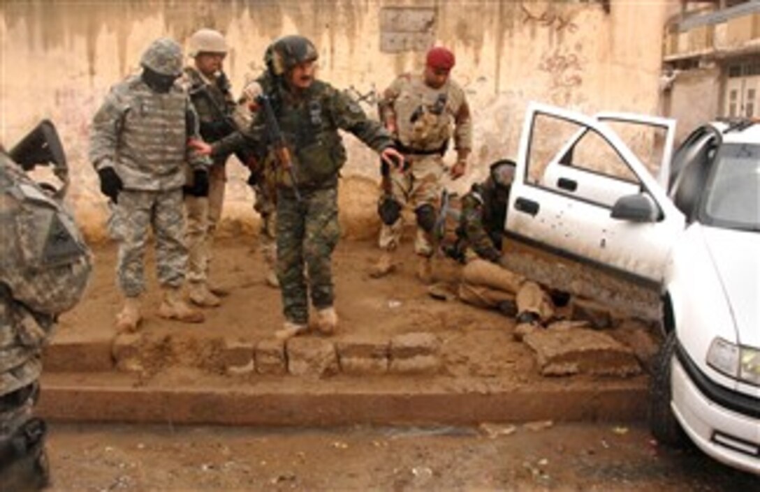 U.S. Army soldiers and Iraqi army soldiers inspect a vehicle after a firefight with insurgents who owned the vehicle in Mosul, Iraq, Jan. 23, 2008. The soldiers are assigned to 2nd Iraqi Army Division, Military Transition Team. 
