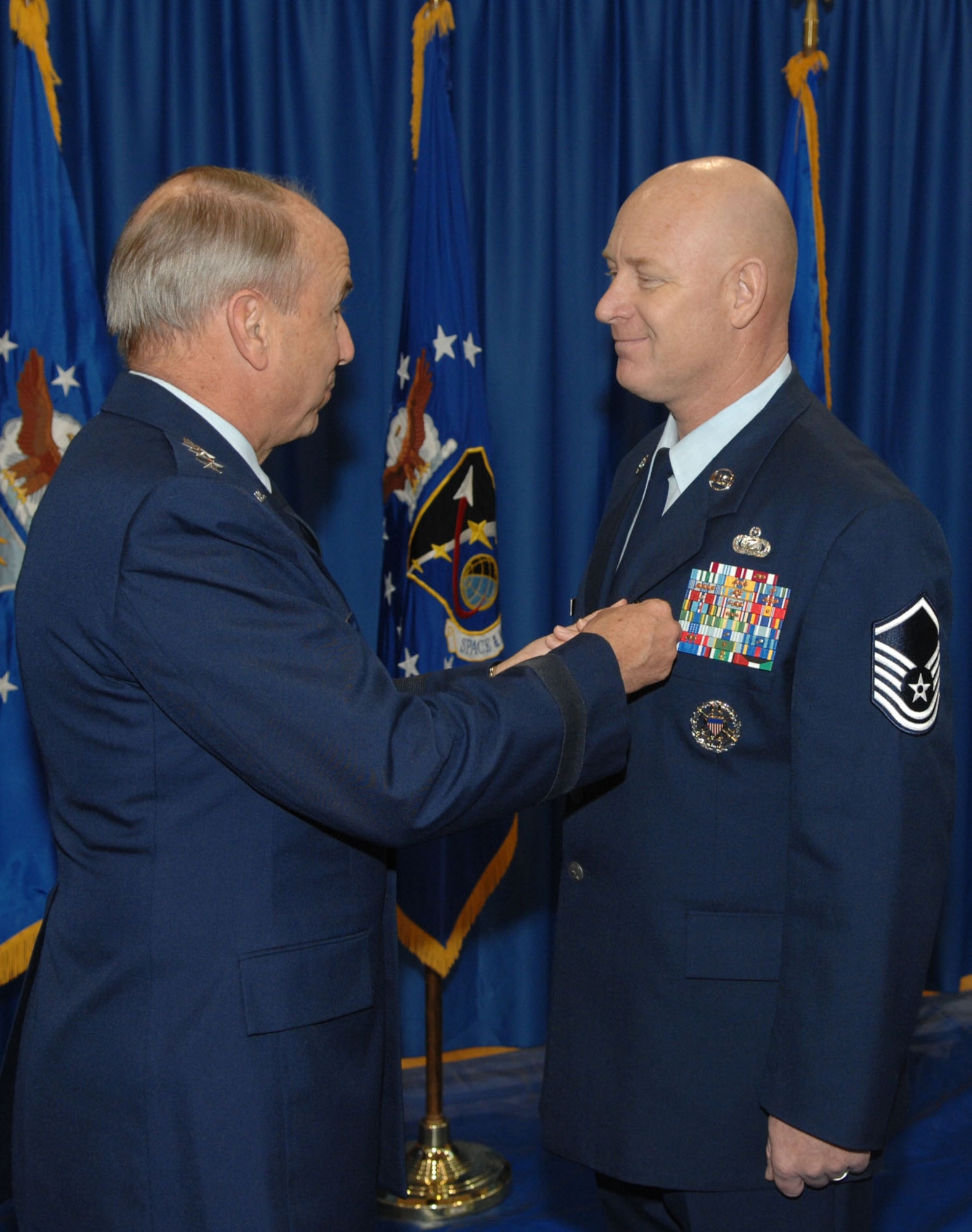 Master Sgt. Michael Garrison receives the Airmen's medal from SMC Commander Lt. Gen. Michael Hamel.