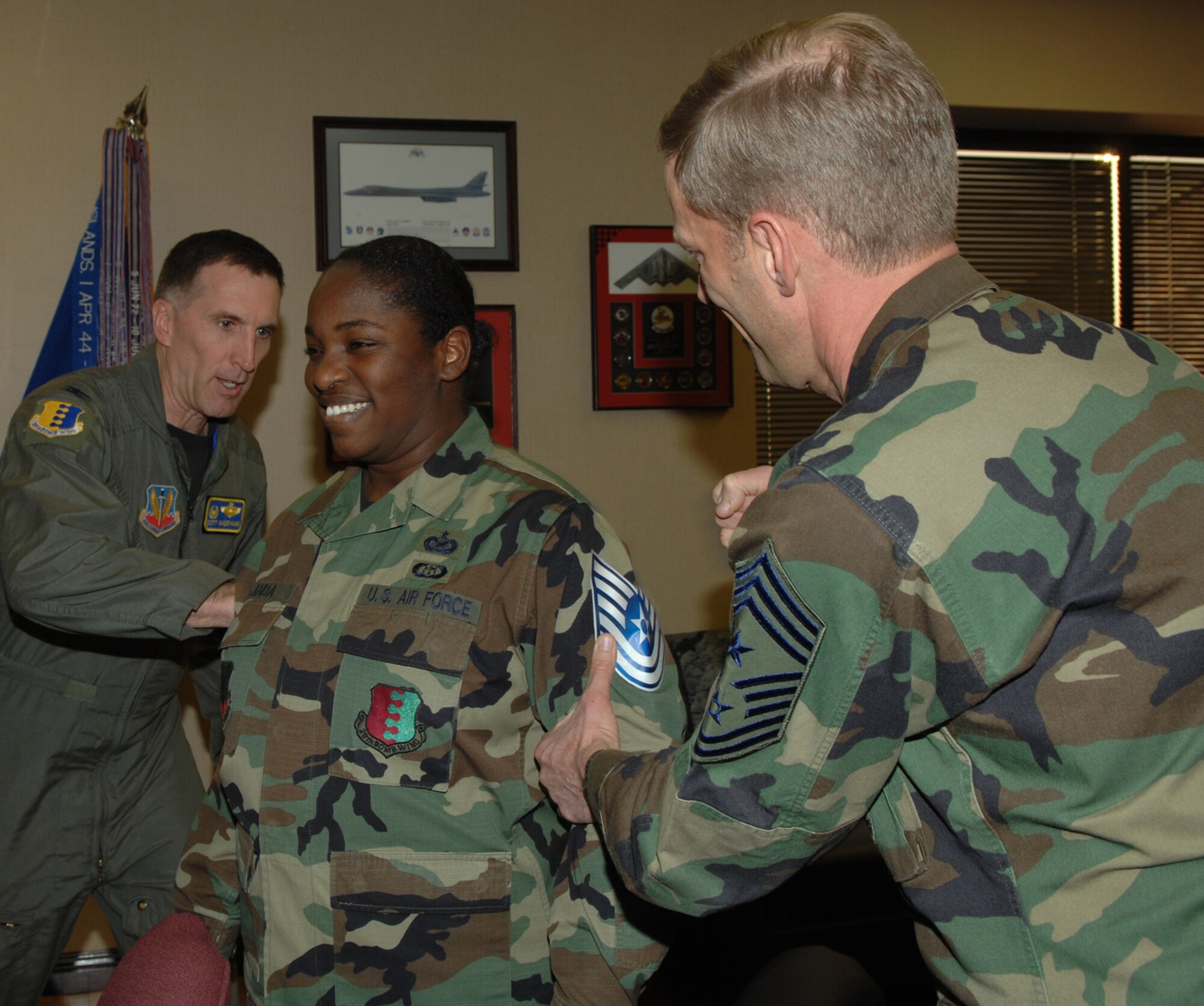 Tech. Sgt. Shanda De Anda, 28th Bomb Wing Public Affairs assistant NCO in
charge, is promoted to the rank of technical sergeant through the Stripes
for Exceptional Performers program, Jan. 28. Col. Scott Vander Hamm, 28th
Bomb Wing commander, and Chief Master Sgt. John Gillette, 28th Bomb Wing command chief, tack on Sergeant De Anda's new stripes. Sergeant De Anda greatly
exceeded the standards as a staff sergeant, earning the immediate promotion, which is given out to only a few Airman nominated for the STEP program throughout the wing.
