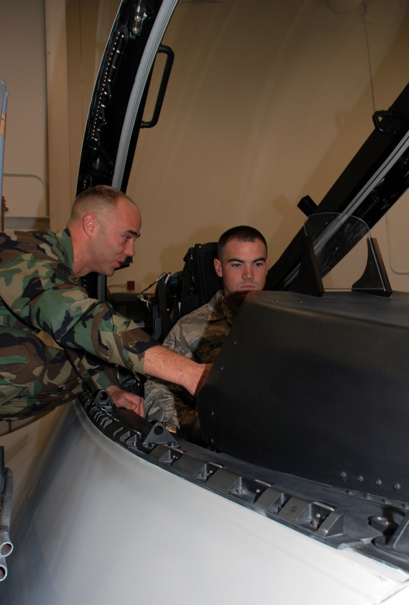 Staff Sgt. Chris Dippold, a F-22 Raptor crew chief course instructor with the 362nd Training Squadron shows Airman 1st Class Michael Borden, an Airmen in Training in the F-22 Raptor crew chief course, the inside of a Raptor cockpit trainer Jan. 29. Airman Borden is one of the first Airmen to attend training in the new Raptor Maintenace Training Facility. (U.S. Air Force photo/Airman 1st Class Jacob Corbin)