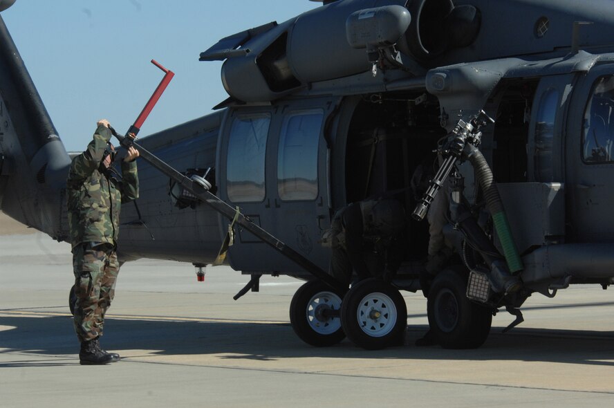 MOODY AIR FORCE BASE, Ga. -- Airman 1st Class James Prima, 723rd Aircraft Maintenance Squadron, places a 600-pound weight under an HH-60G Pave Hawk for a hoist weight check Jan. 30 here. These checks are preformed anytime a hoist line has been replaced. (U.S. Air Force photo by Airman 1st Class Gina Chiaverotti) 