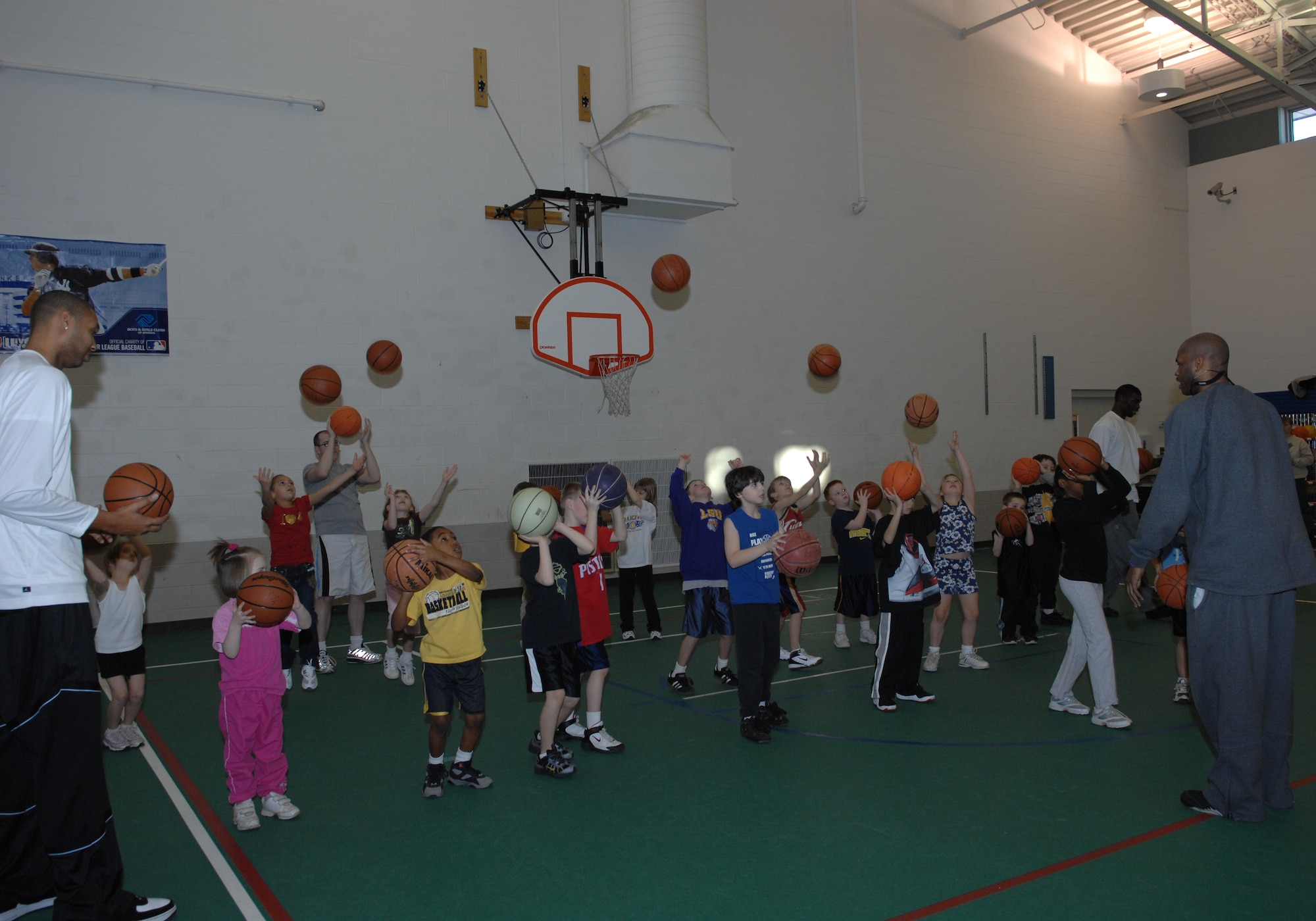 MINOT AIR FORCE BASE, N.D. -- Minot Skyrockets center Lee Scruggs and forward Kevin Rice help children develop their shooting form at the David C. Jones Youth Center here Jan. 26. The Skyrockets held a free basketball camp for youth, ages 5-18. (U.S. Air Force photo by Airman 1st Class Sharida Bishop)