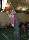 MINOT AIR FORCE BASE, N.D. -- Minot Skyrockets forward Kevin Rice lifts Hannah Tole, daughter of Lt. Col. Timothy Tole, 91st Missile Security Forces Squadron commander, up for a slam at the David C. Jones Youth Center here Jan. 26. The Skyrockets held a free basketball camp for youth, ages 5-18. (U.S. Air Force photo by Airman 1st Class Sharida Bishop).